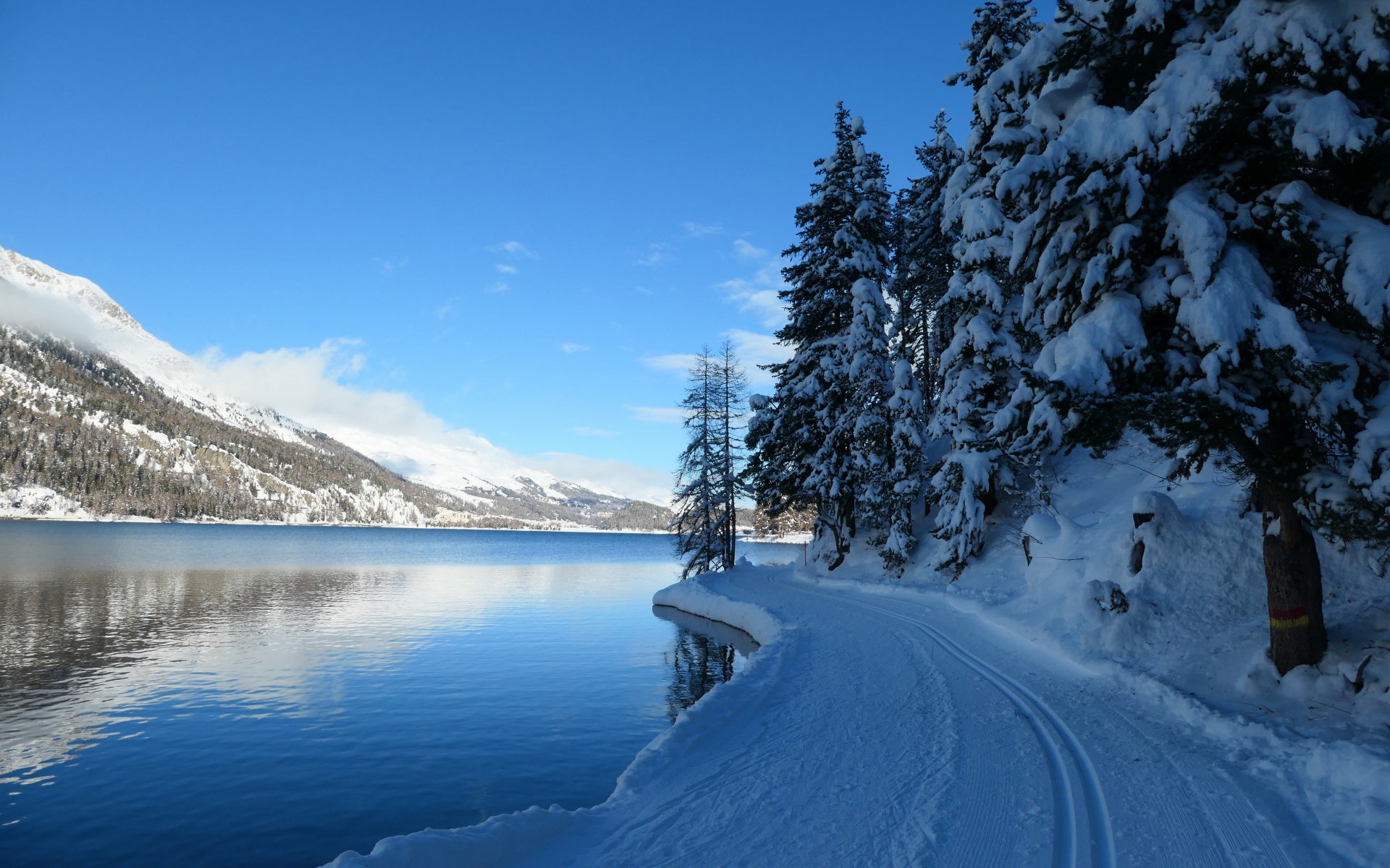 Snow covered road by the lake