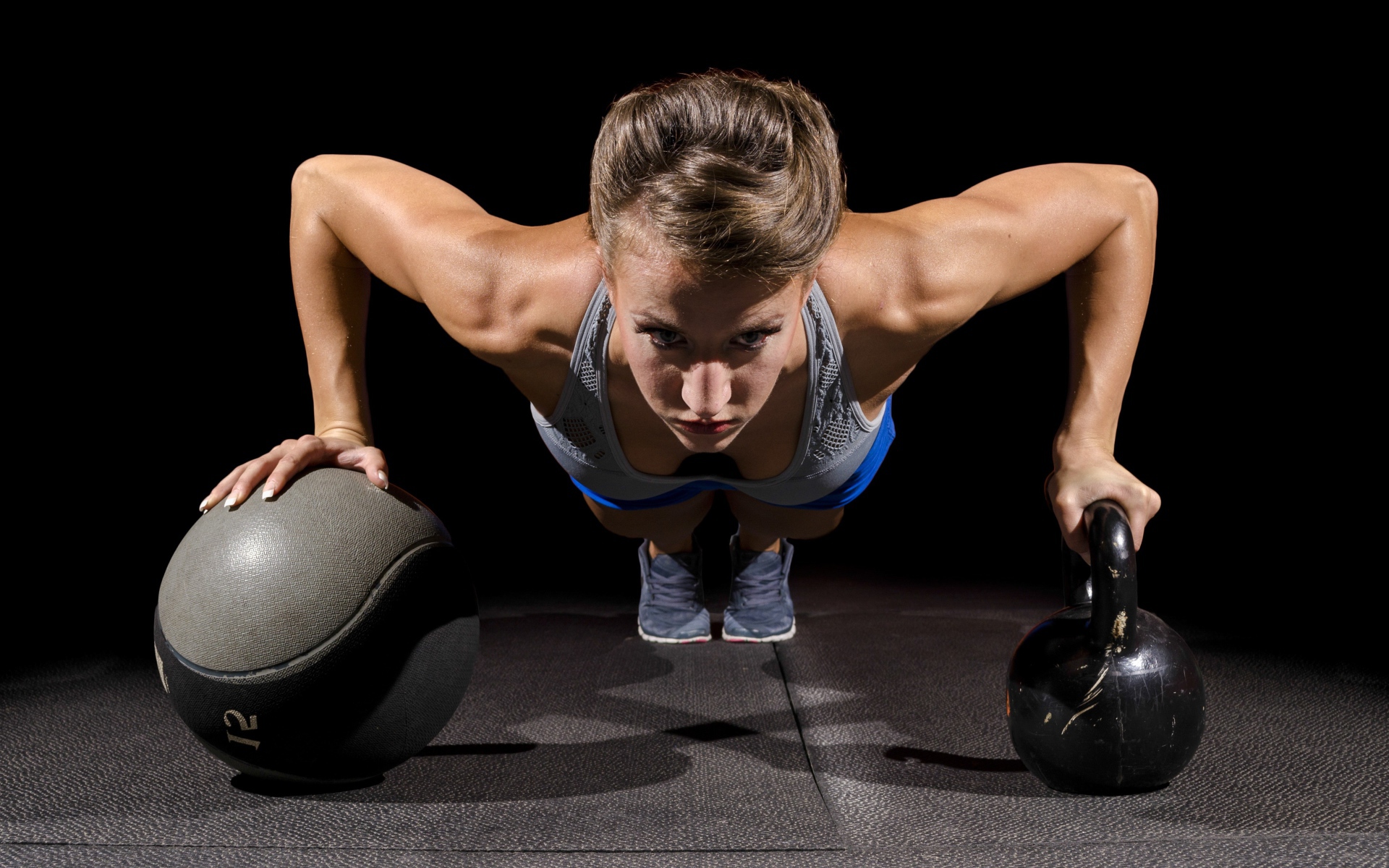 Девушка отжимается с гирями