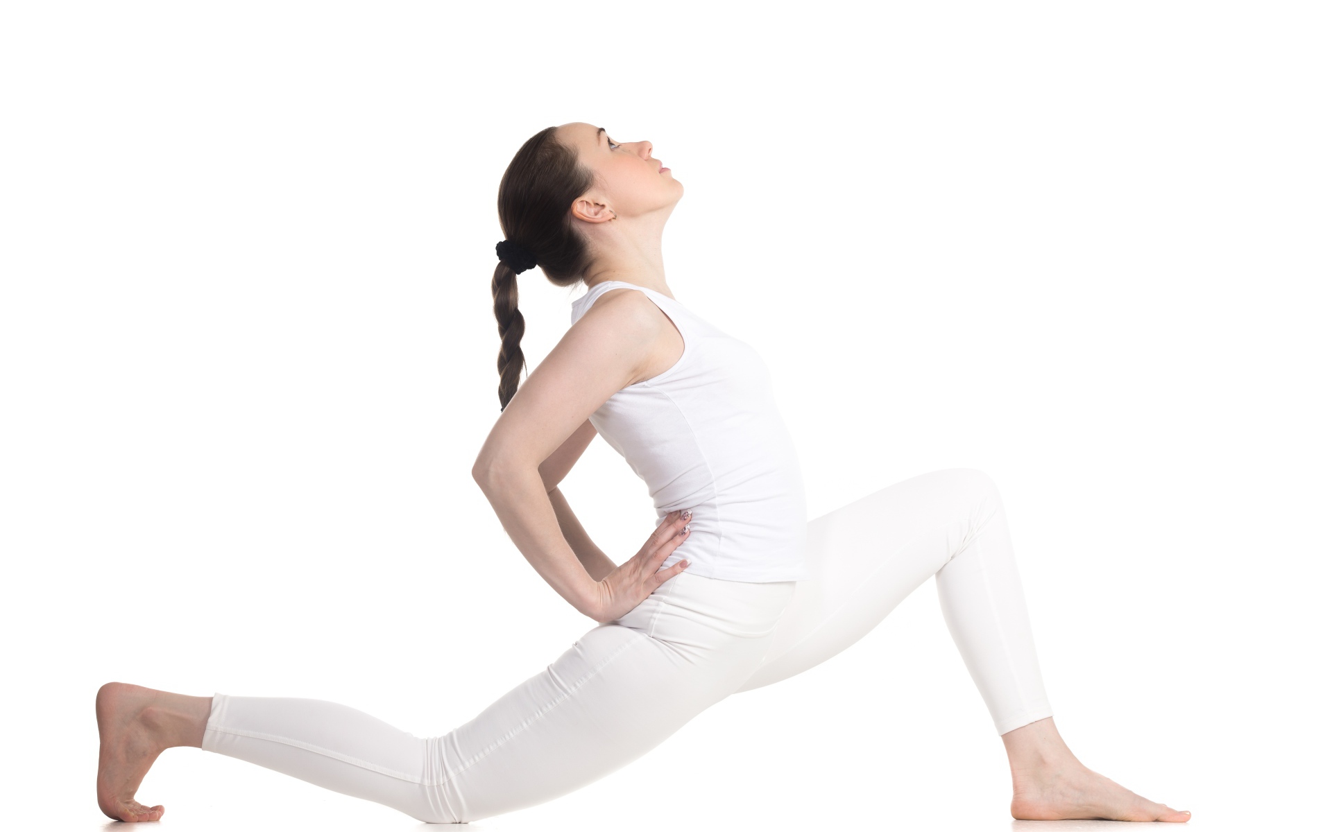Девушка в белом костюме делает растяжку