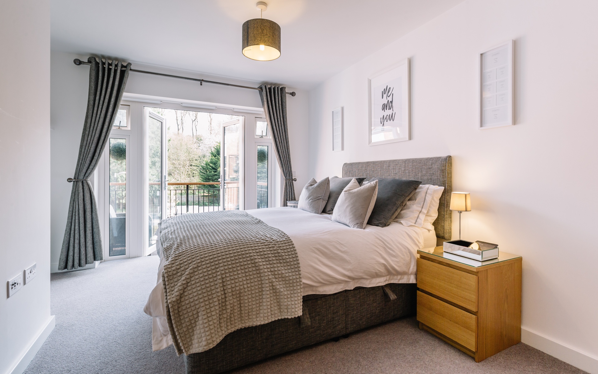 Большая высокая кровать в комнате с большим окном с балконом