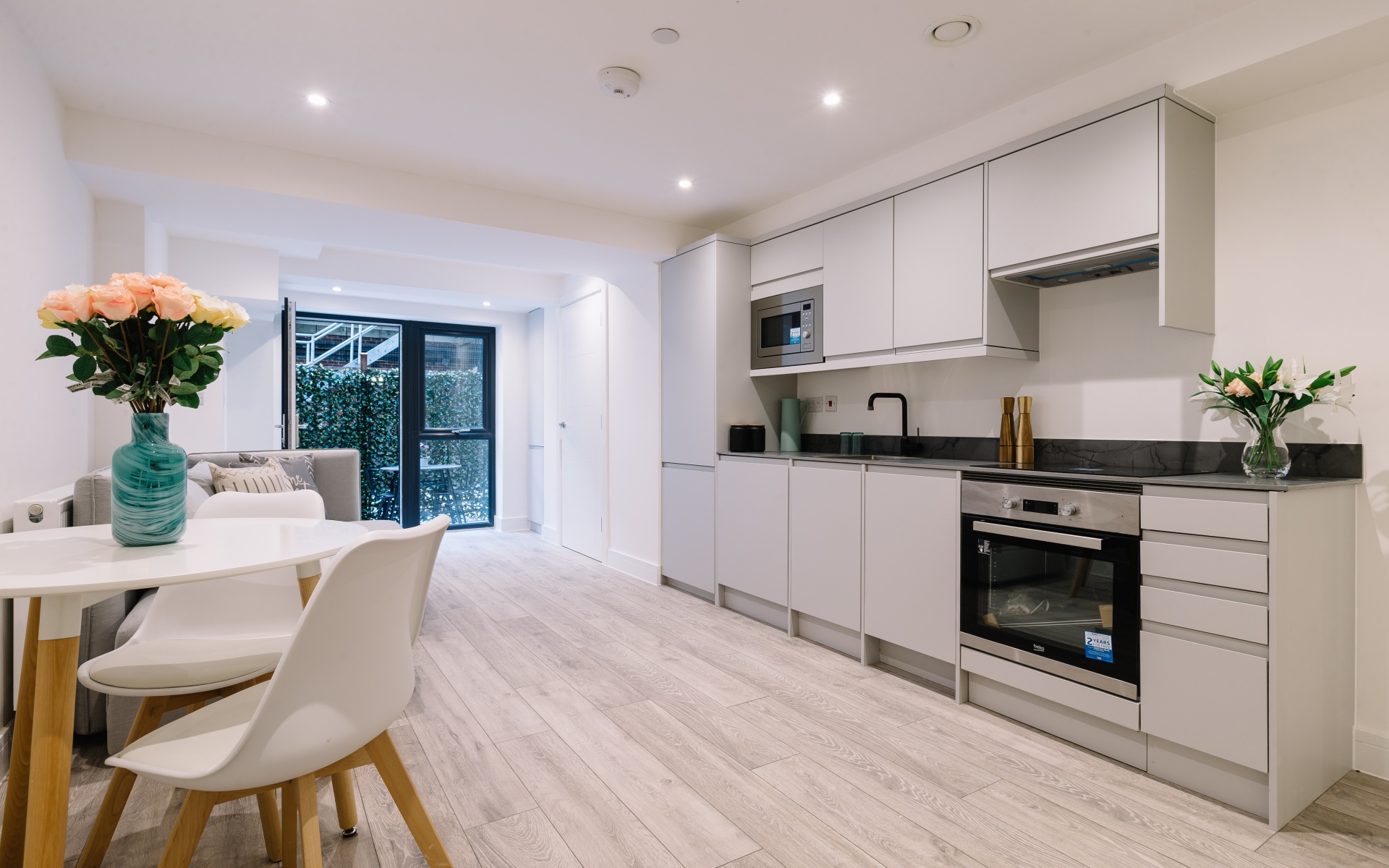 Большая просторная белая гостиная с букетом роз