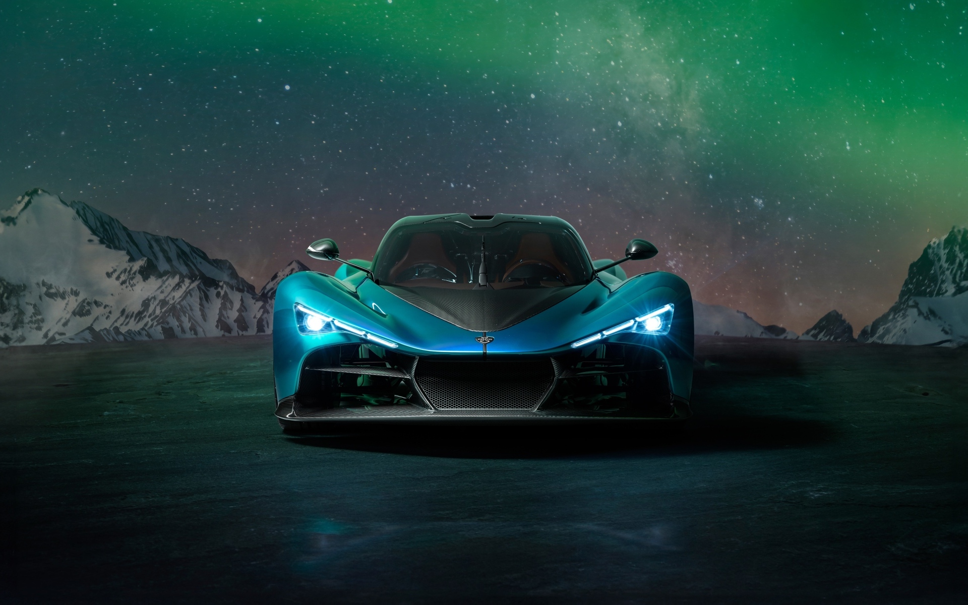 Голубой спортивный автомобиль Zenvo Aurora на фоне гор и полярного сияния
