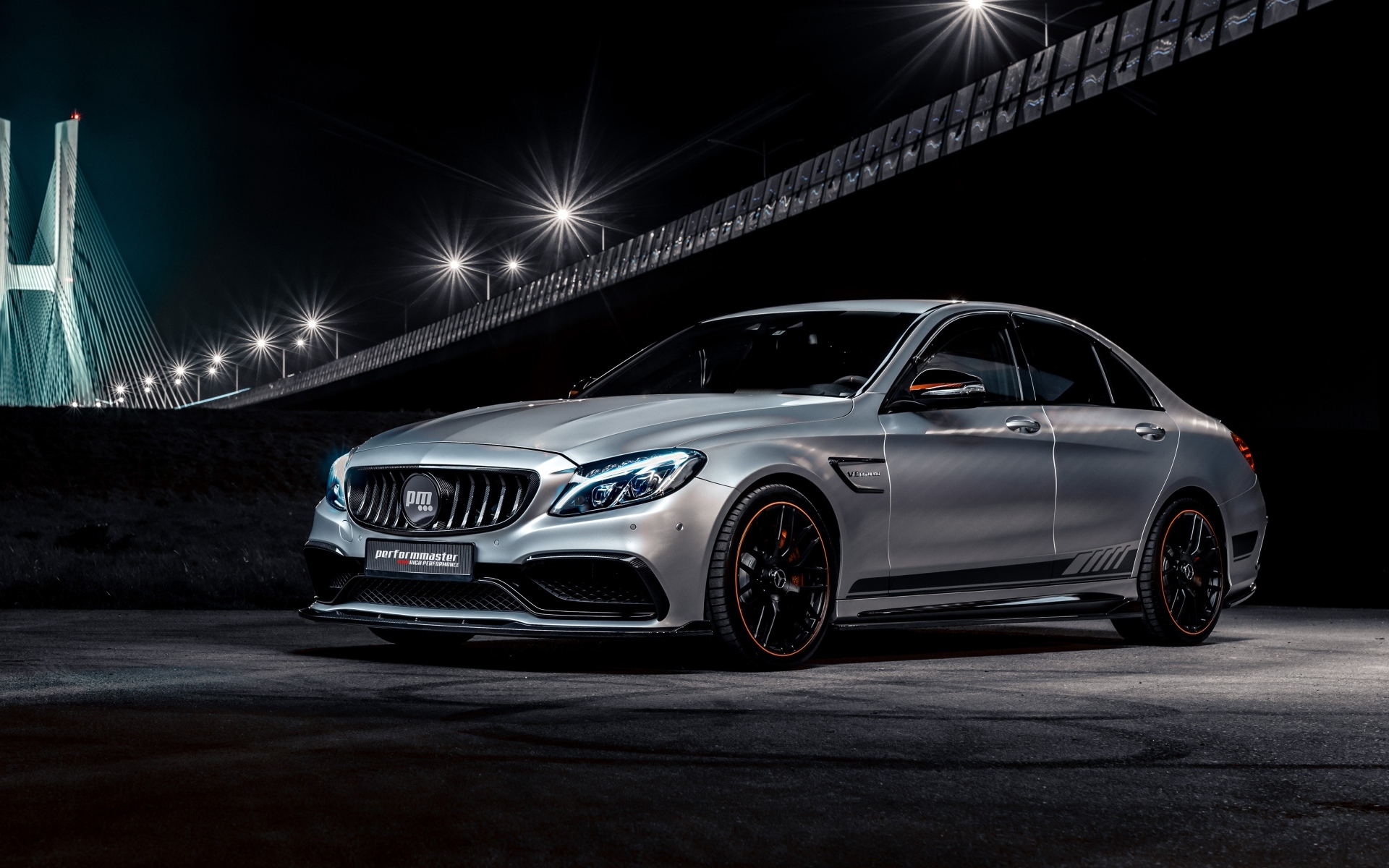 Серебристый автомобиль Performmaster C 63 V8 под мостом