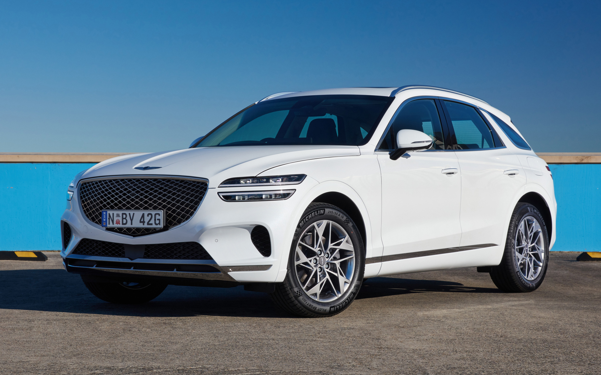 Белый Genesis GV70 2.5T на фоне неба 