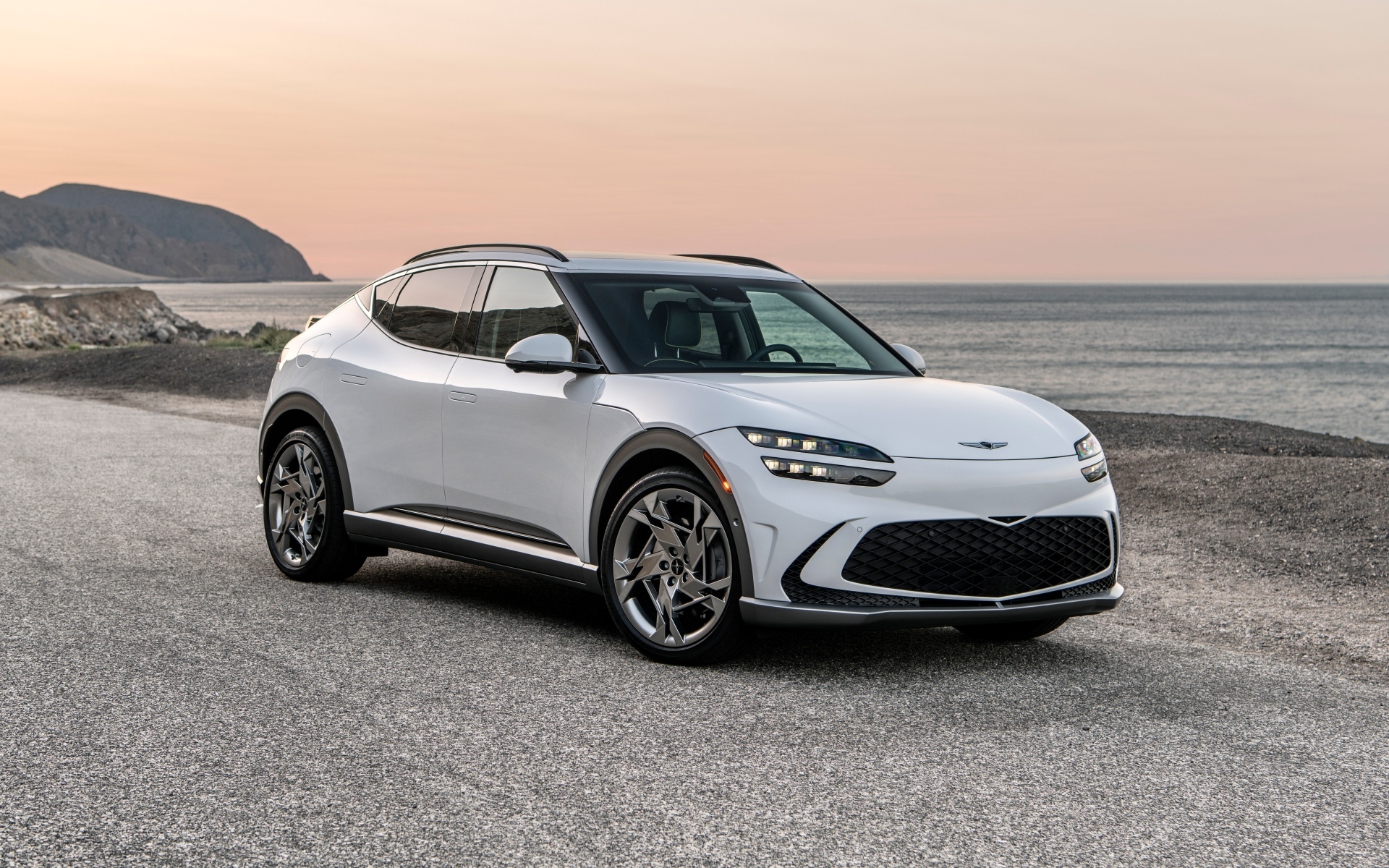 Белый автомобиль Genesis GV60, 2023 года на пляже