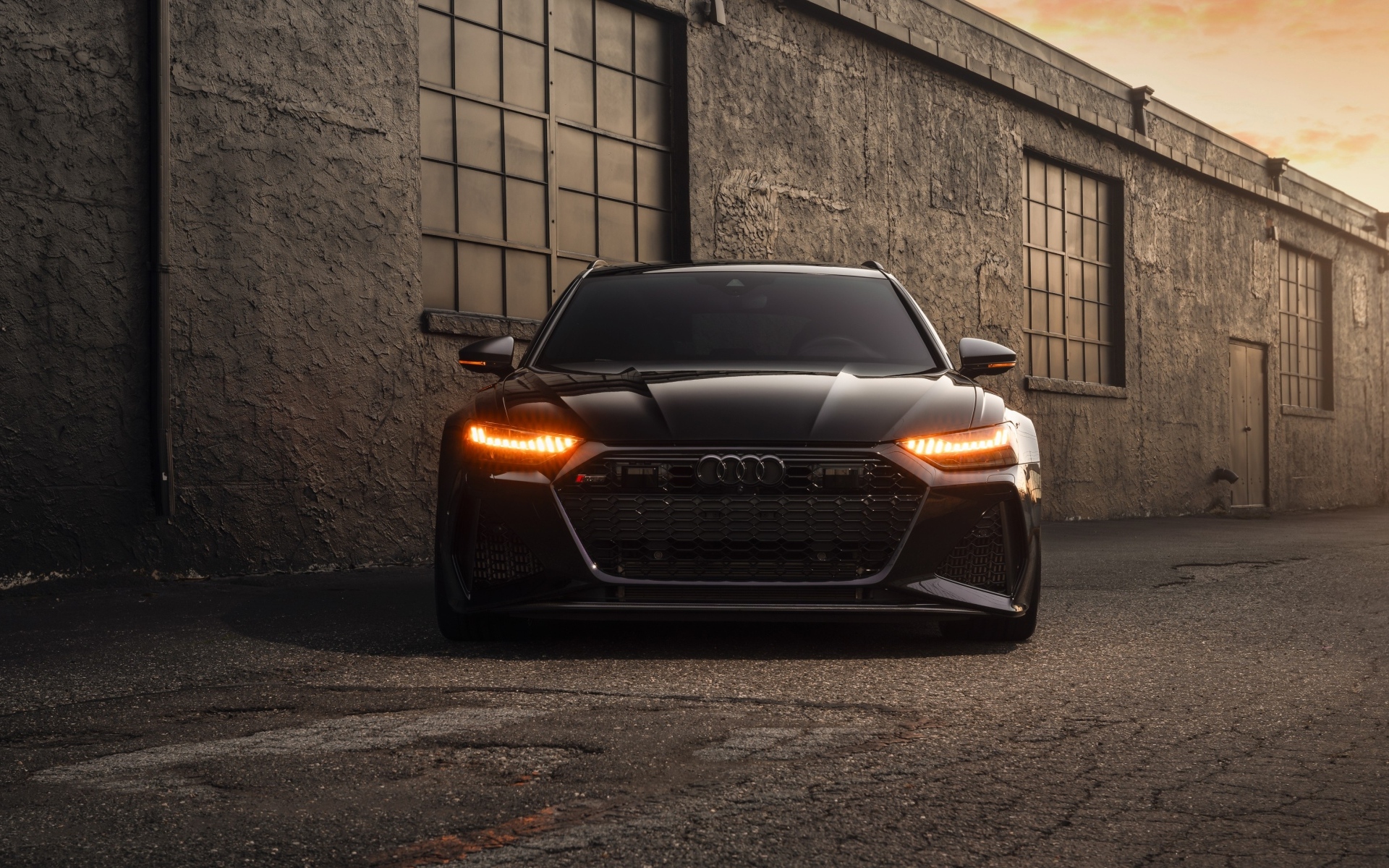 Черный автомобиль Audi RS7 у стены