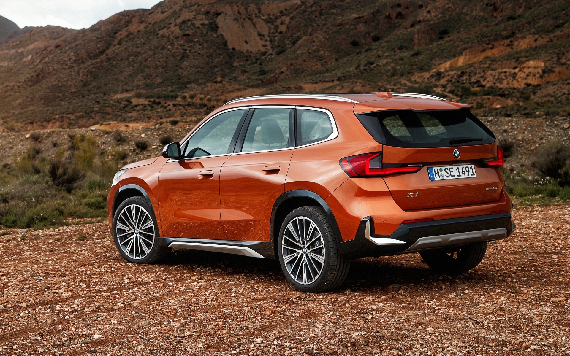 Красный автомобиль BMW X1  вид сзади