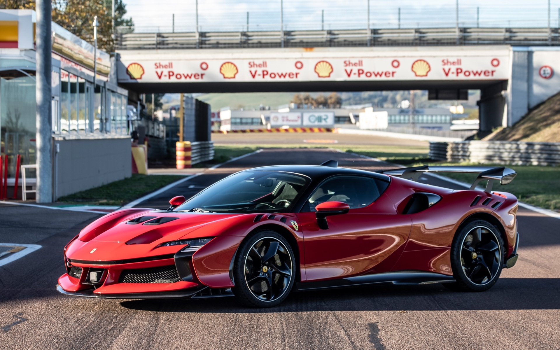 Красный автомобиль Ferrari SF90 XX Stradale на стадионе