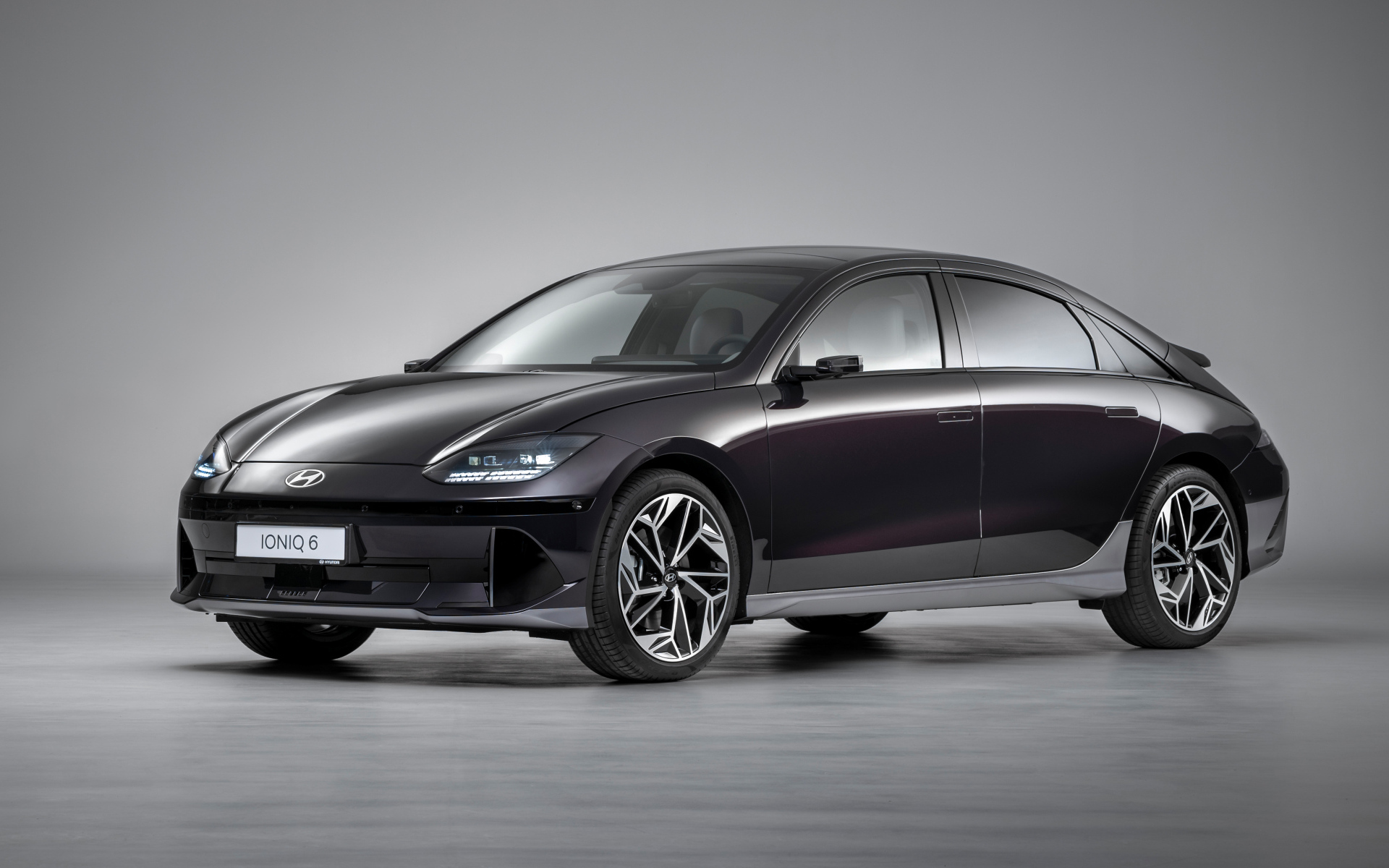 Черный автомобиль Hyundai IONIQ 6 2022 года на сером фоне