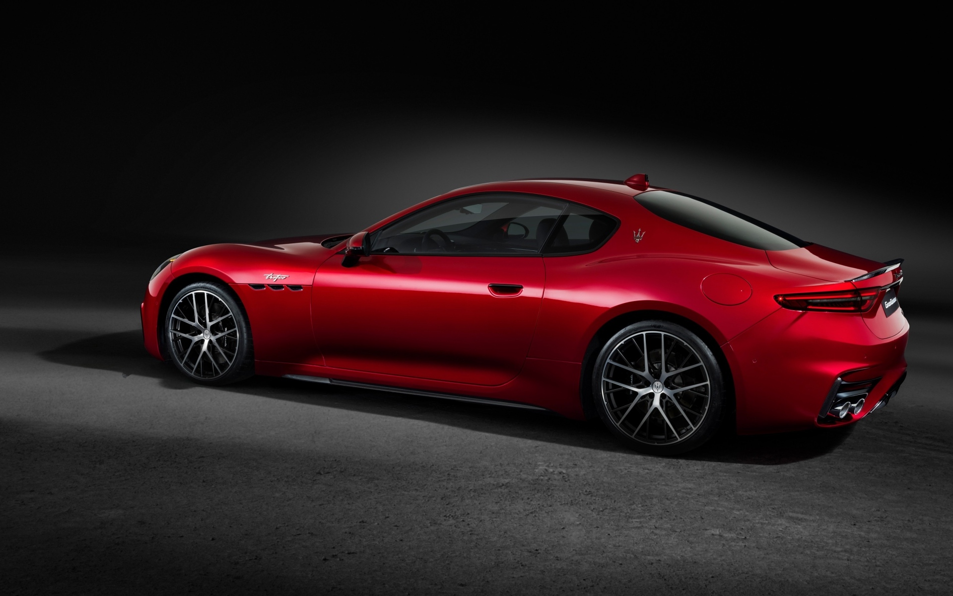 Красный автомобиль Maserati GranTurismo Trofeo 2023 на сером фоне