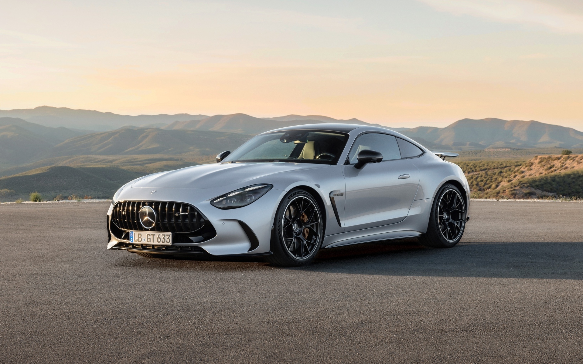 Серебристый автомобиль Mercedes-AMG GT 63 4MATIC+ 2023 года на фоне гор