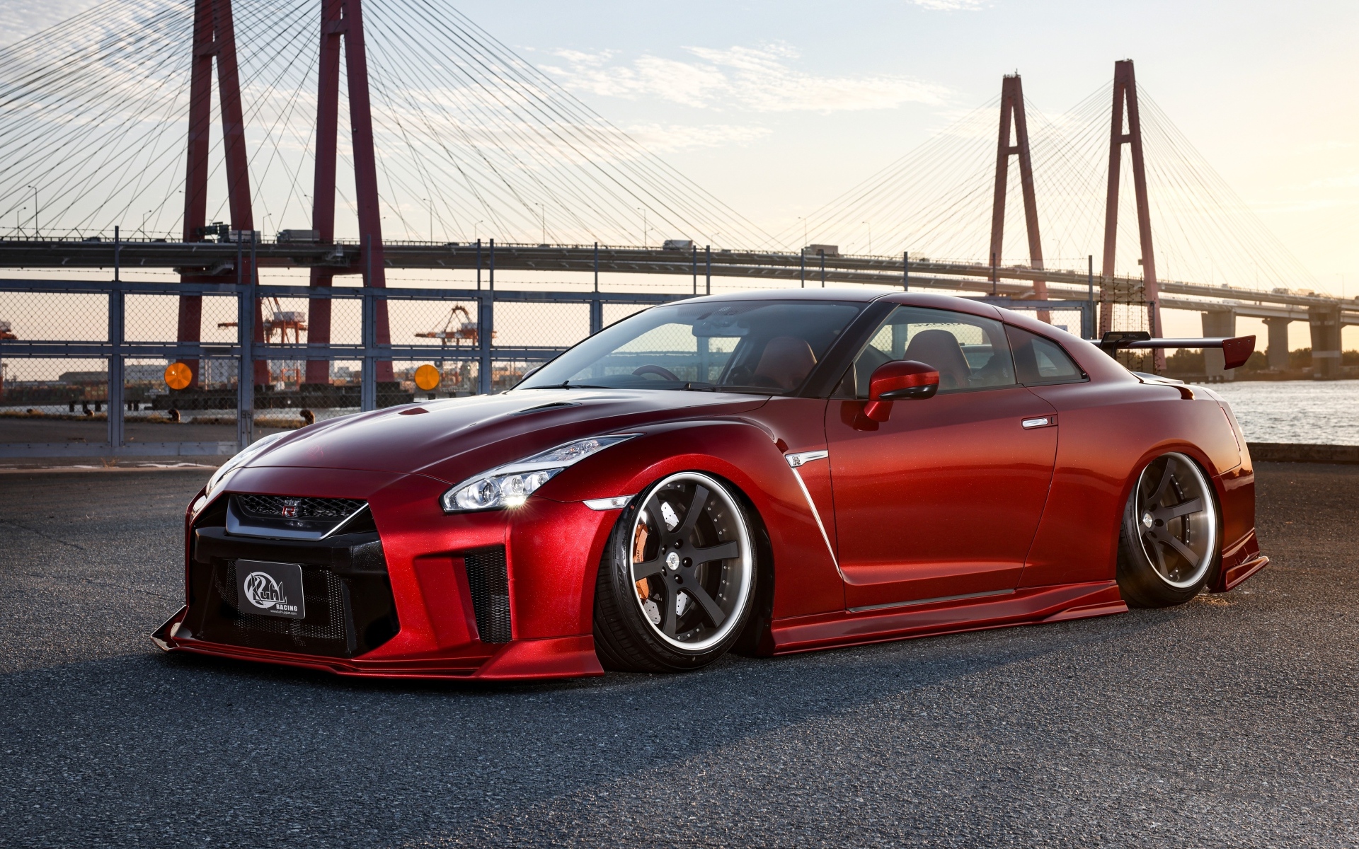 Красный автомобиль Nissan GTR 35R на фоне моста