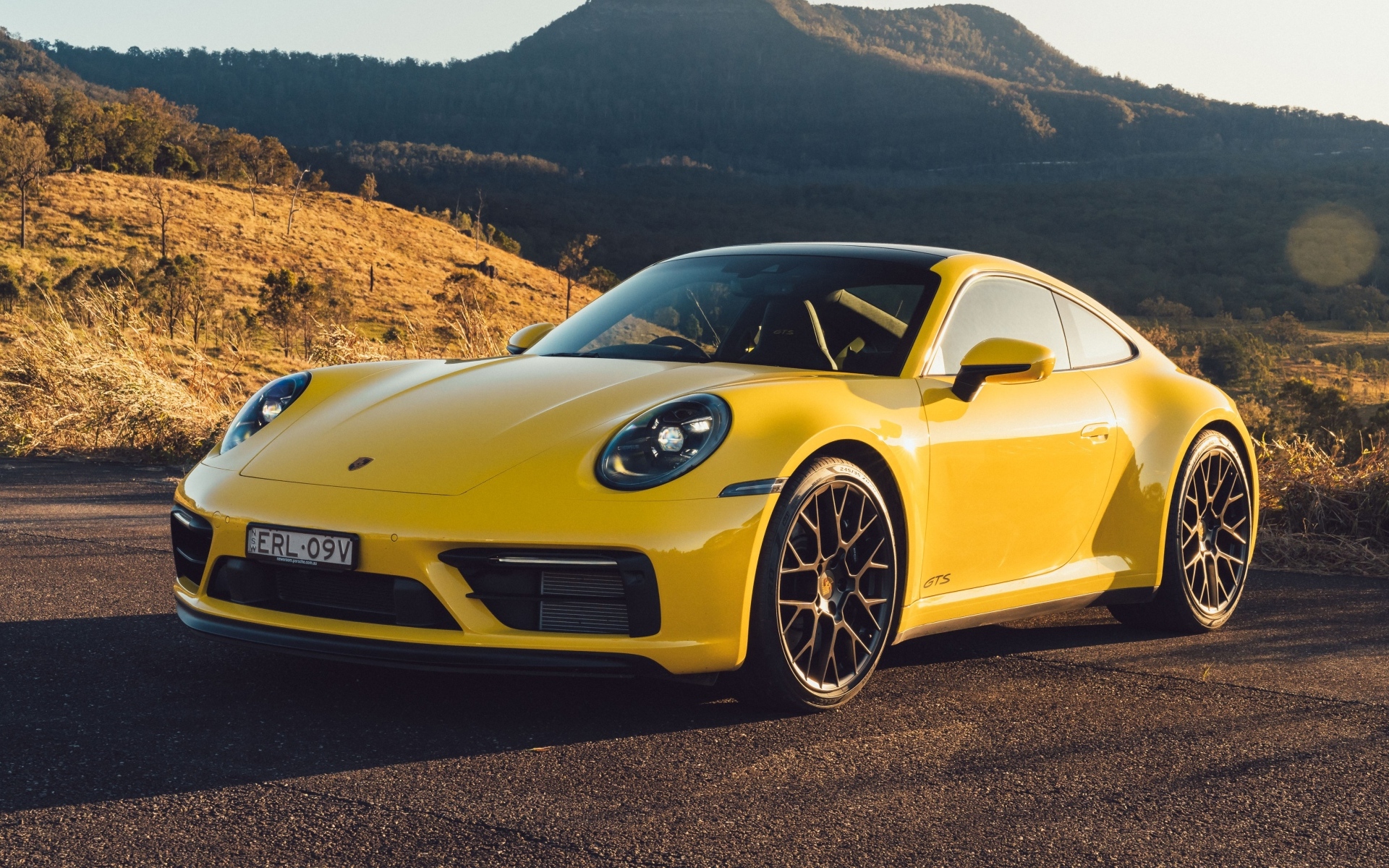 Желтый быстрый автомобиль Porsche 911 Carrera GTS вид спереди