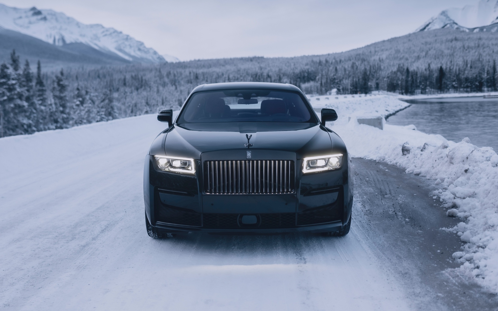 Черный автомобиль Rolls-Royce Black Badge Ghost  на зимней дороге