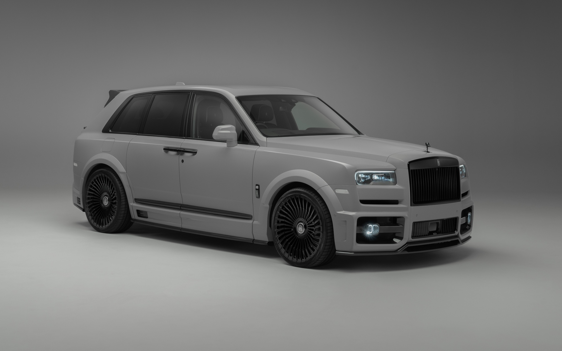 Автомобиль Rolls-Royce Cullinan на сером фоне