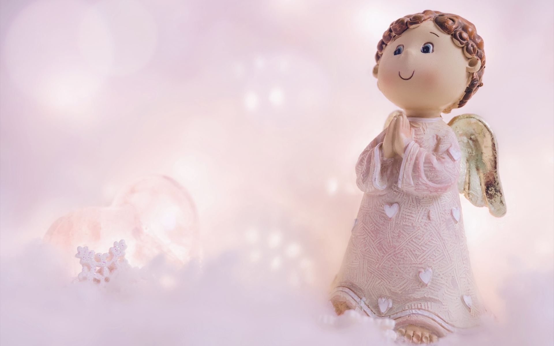 Статуэтка ангела на розовом фоне