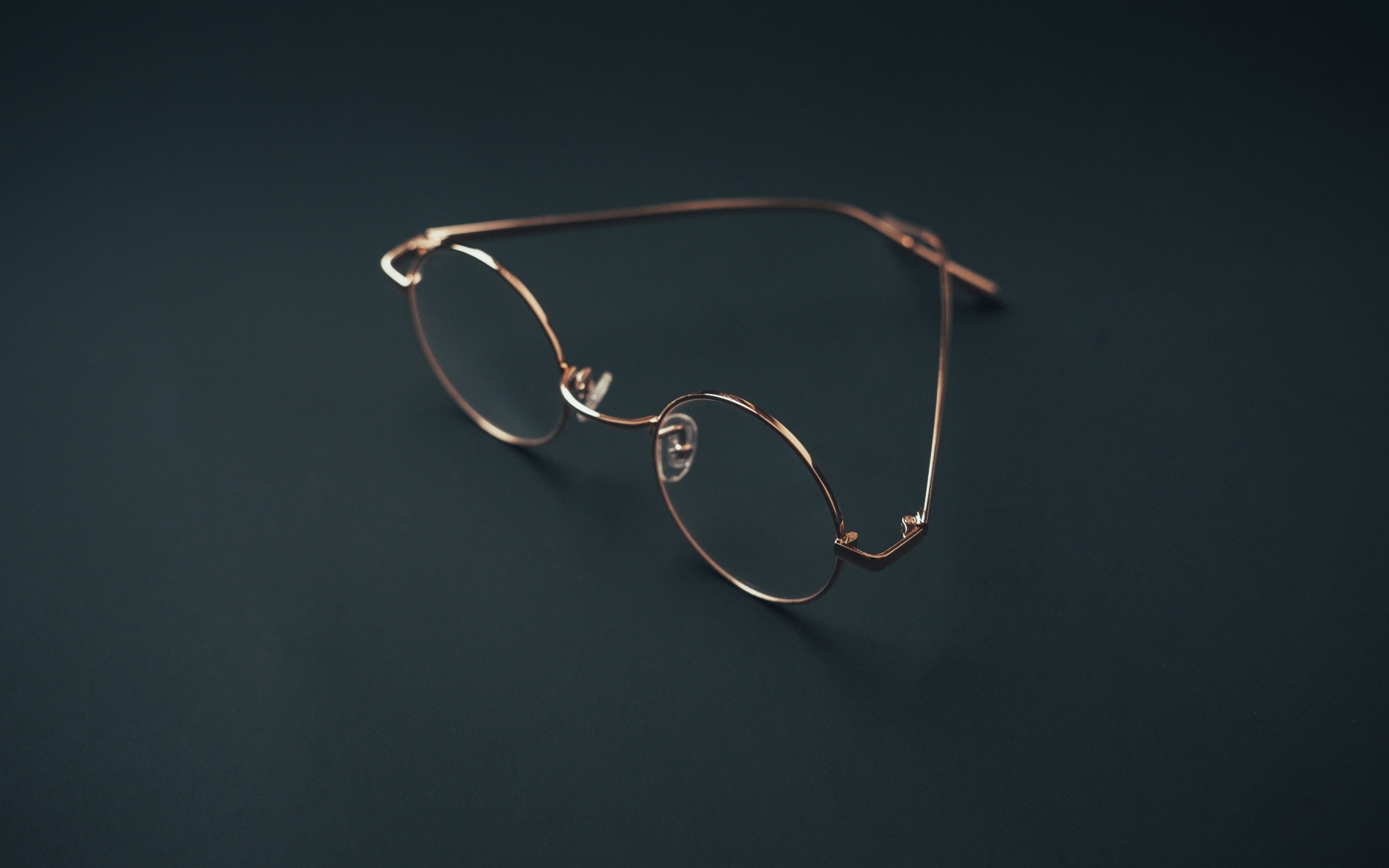 Очки лежат на серой поверхности