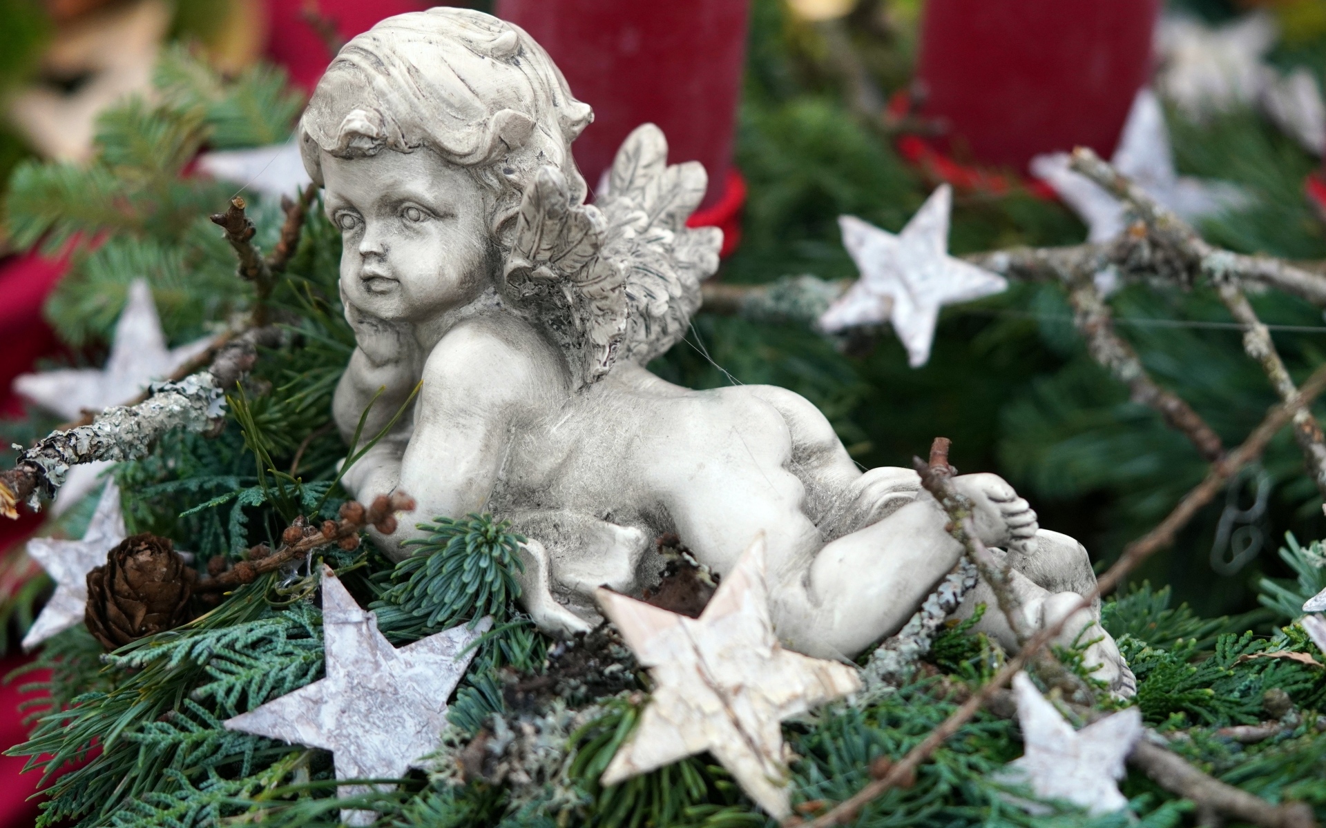 Статуэтка ангел лежит на ветках туи