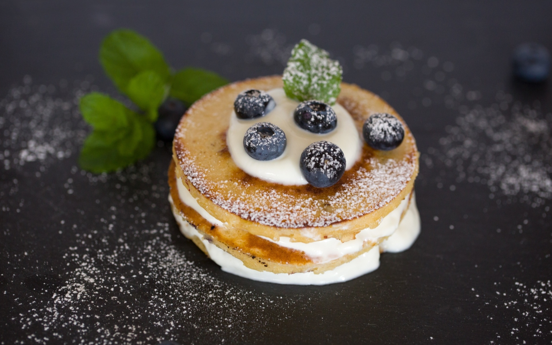 Оладьи с кремом и ягодами черники на столе