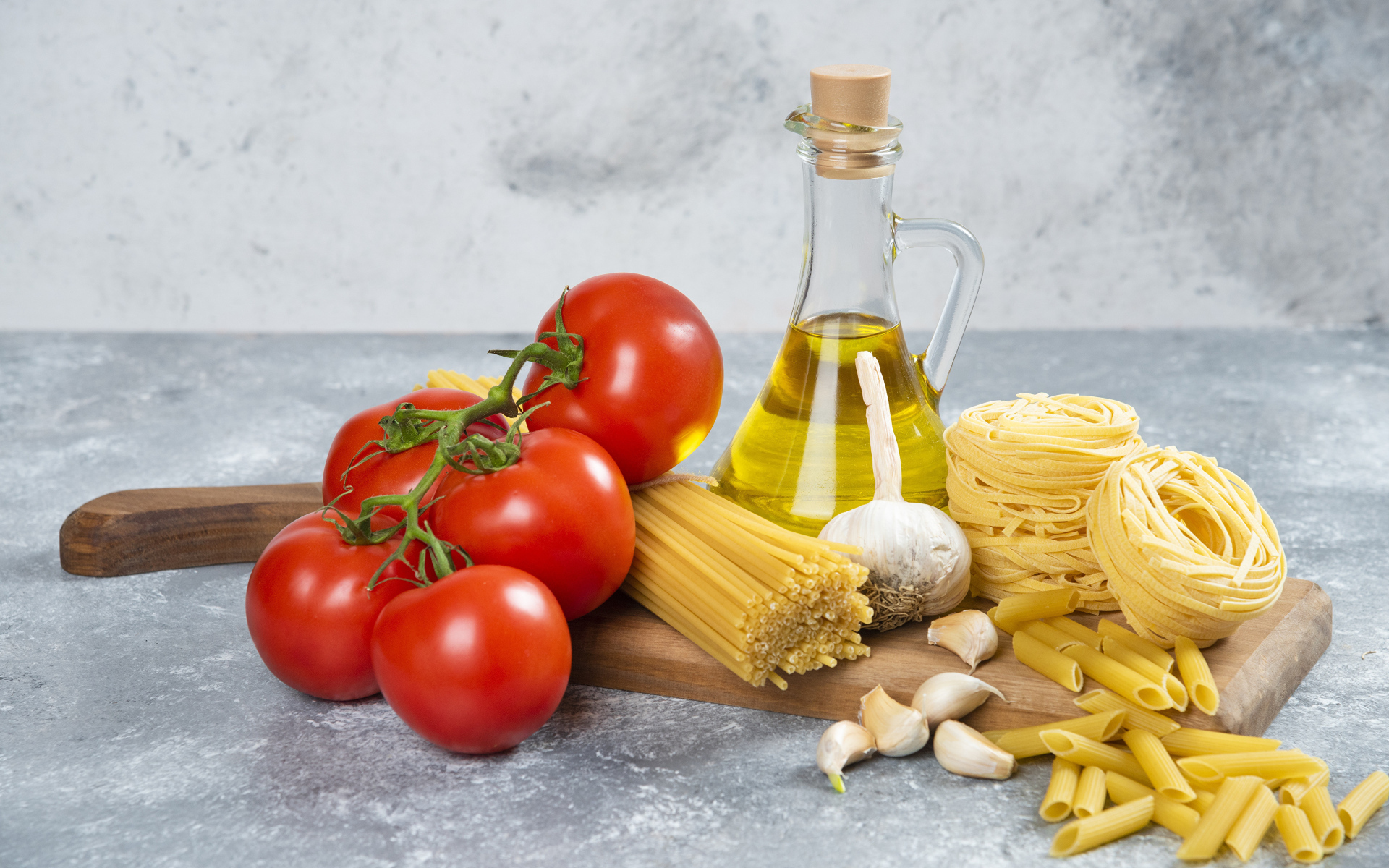 Паста, помидоры и масло на столе