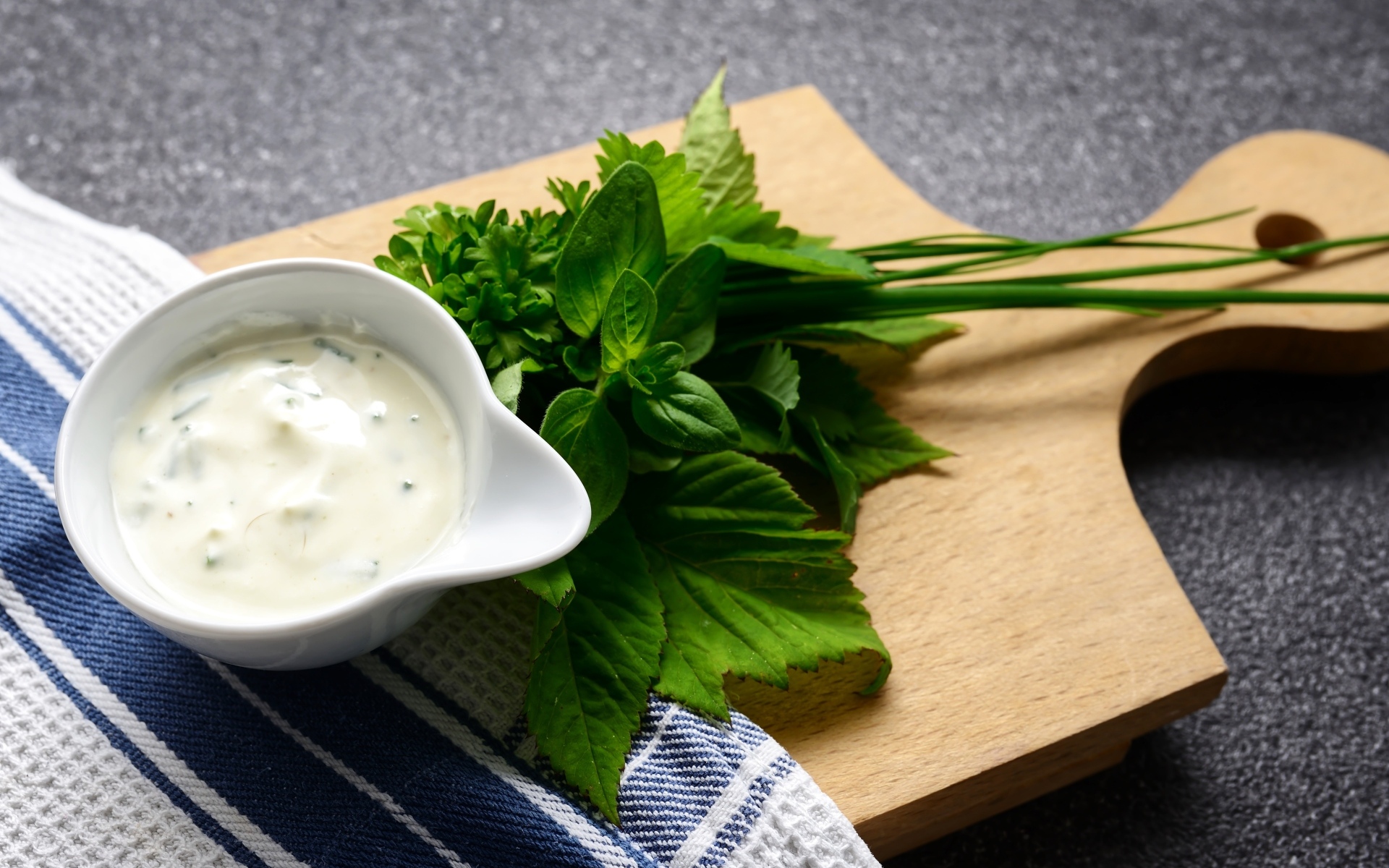 Соус с зеленью на деревянной доске 