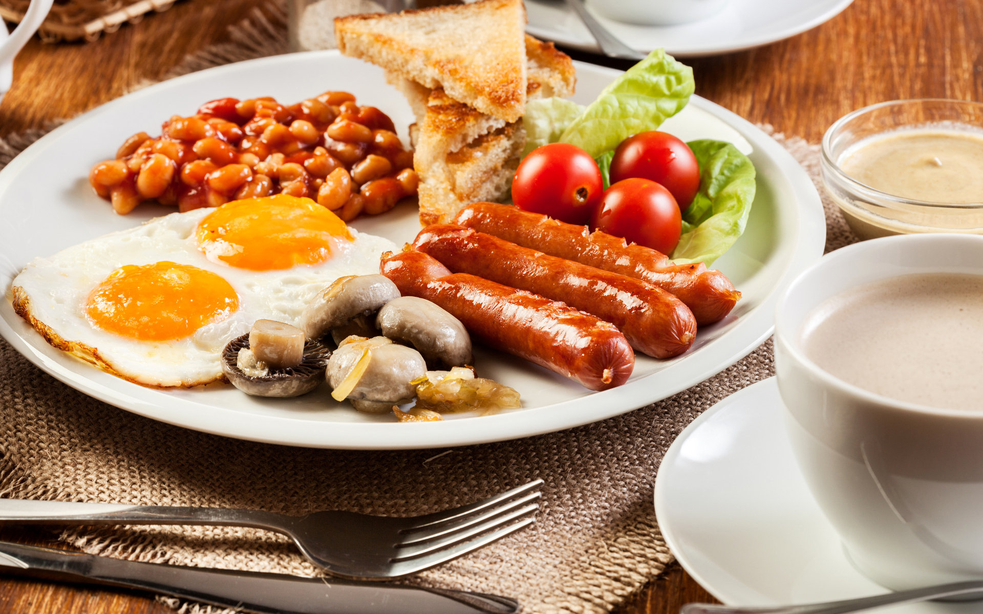Яичница, сосиски и овощи на тарелке на завтрак