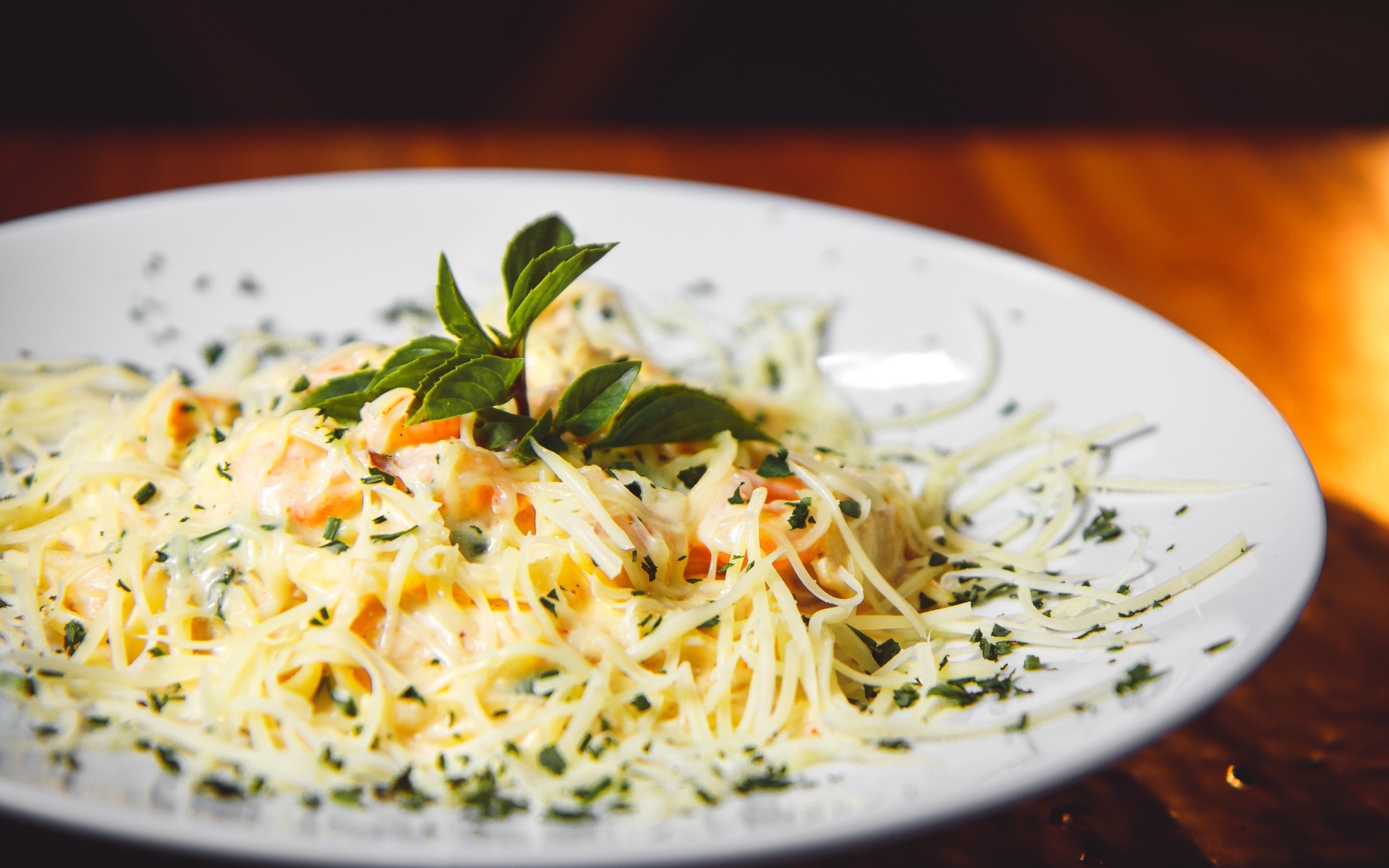 Спагетти с сыром и помидорами на белой тарелке