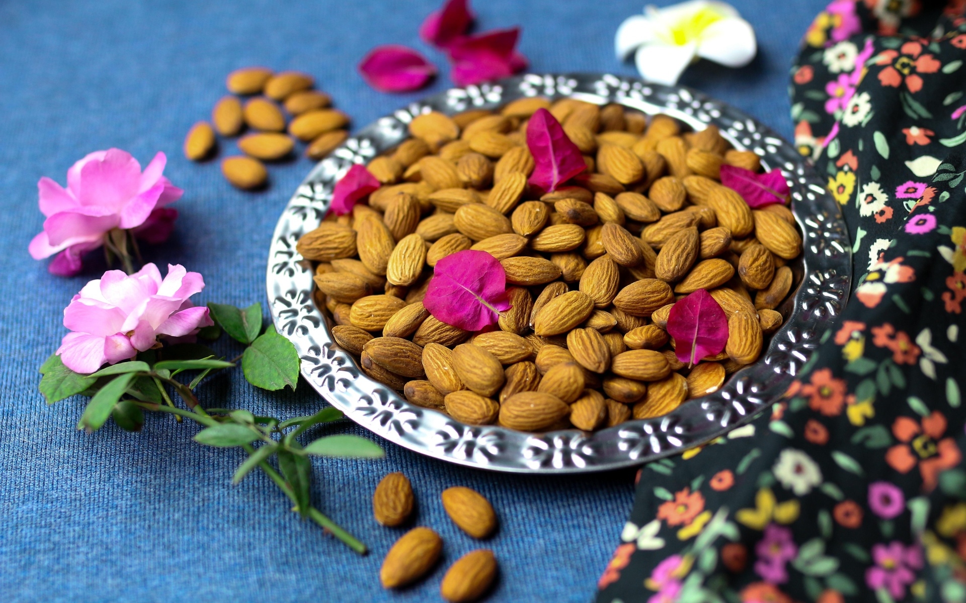 Вкусные миндальные орехи на тарелке с цветами