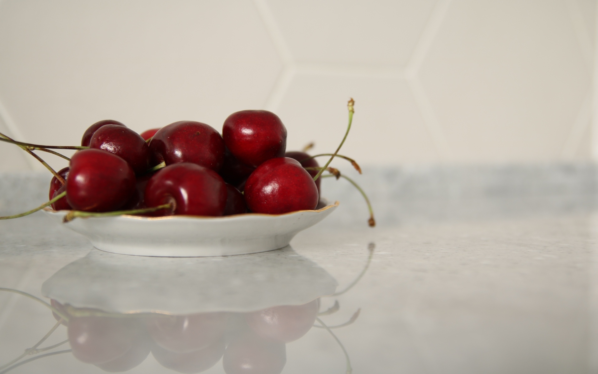 Вкусные сладкие черешни на белой тарелке