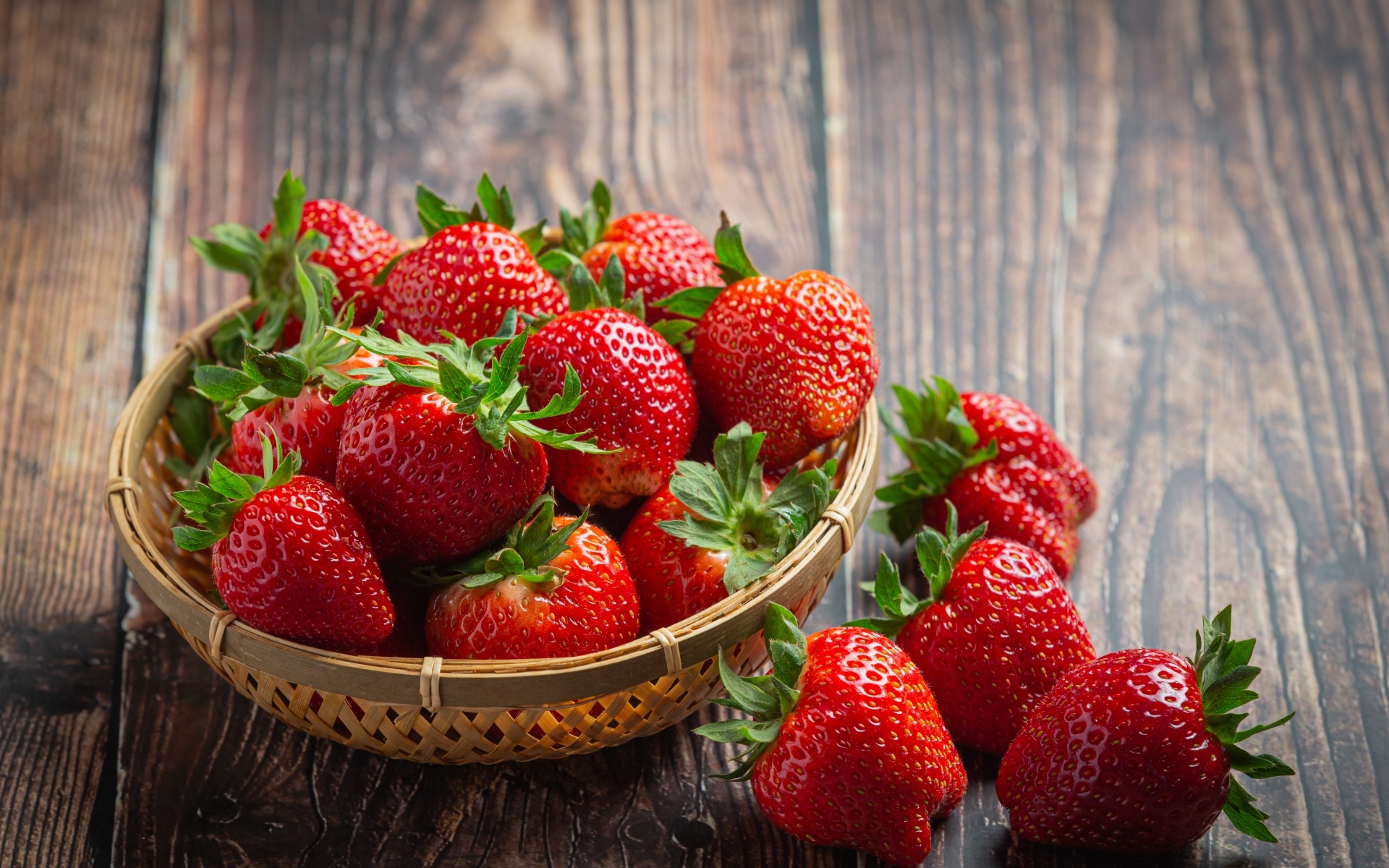 Много спелой красной клубники в деревянной посуде 