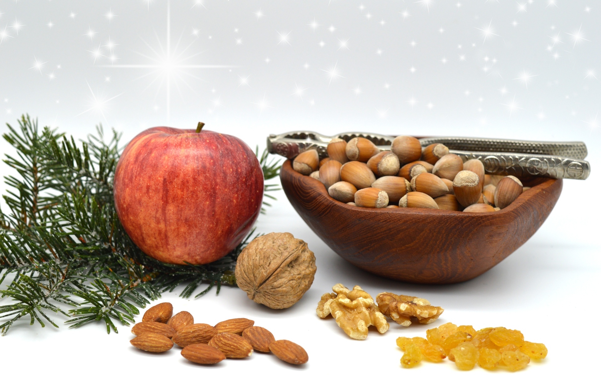 Орехи с яблоком и еловой веткой на столе