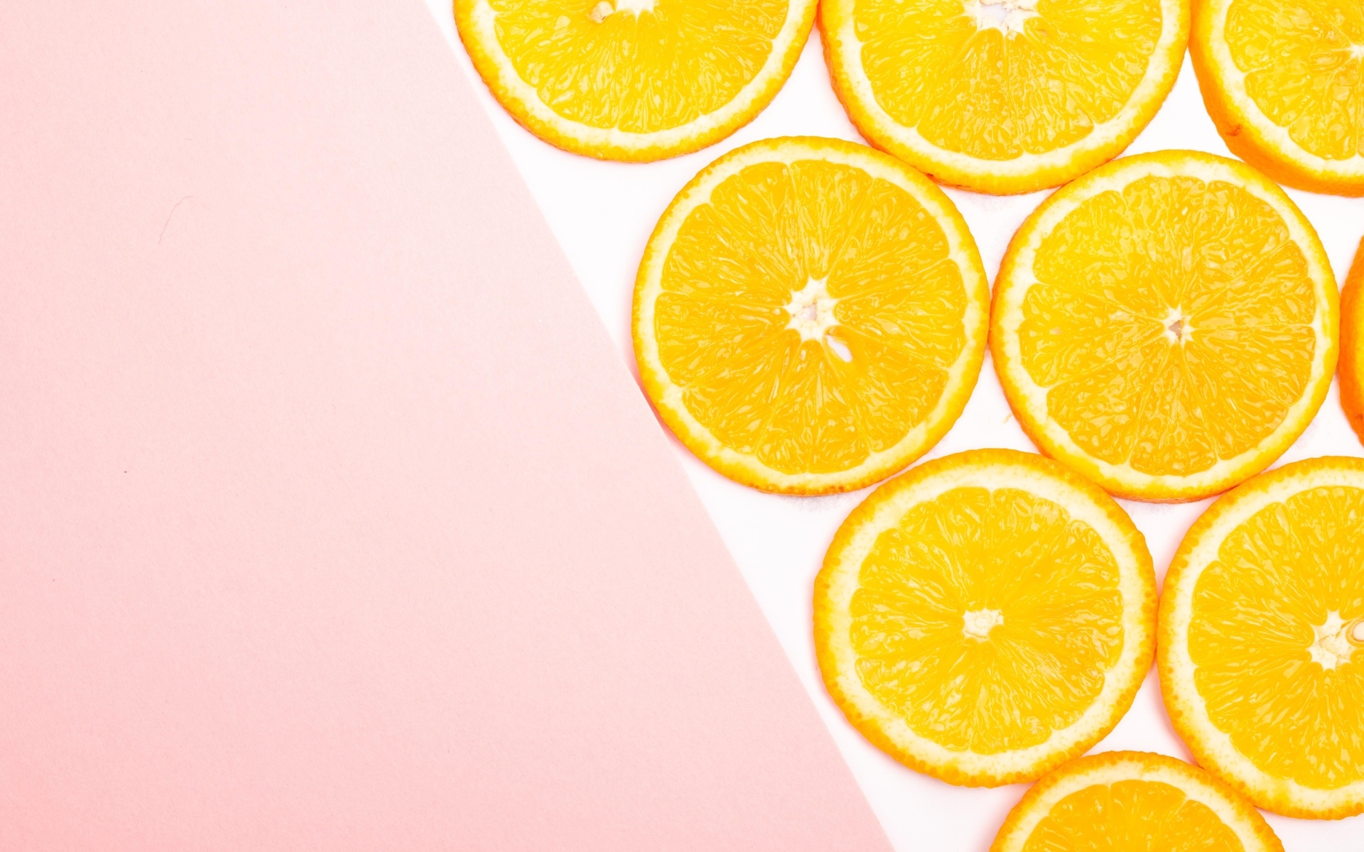 Кружочки апельсина на розовом фоне