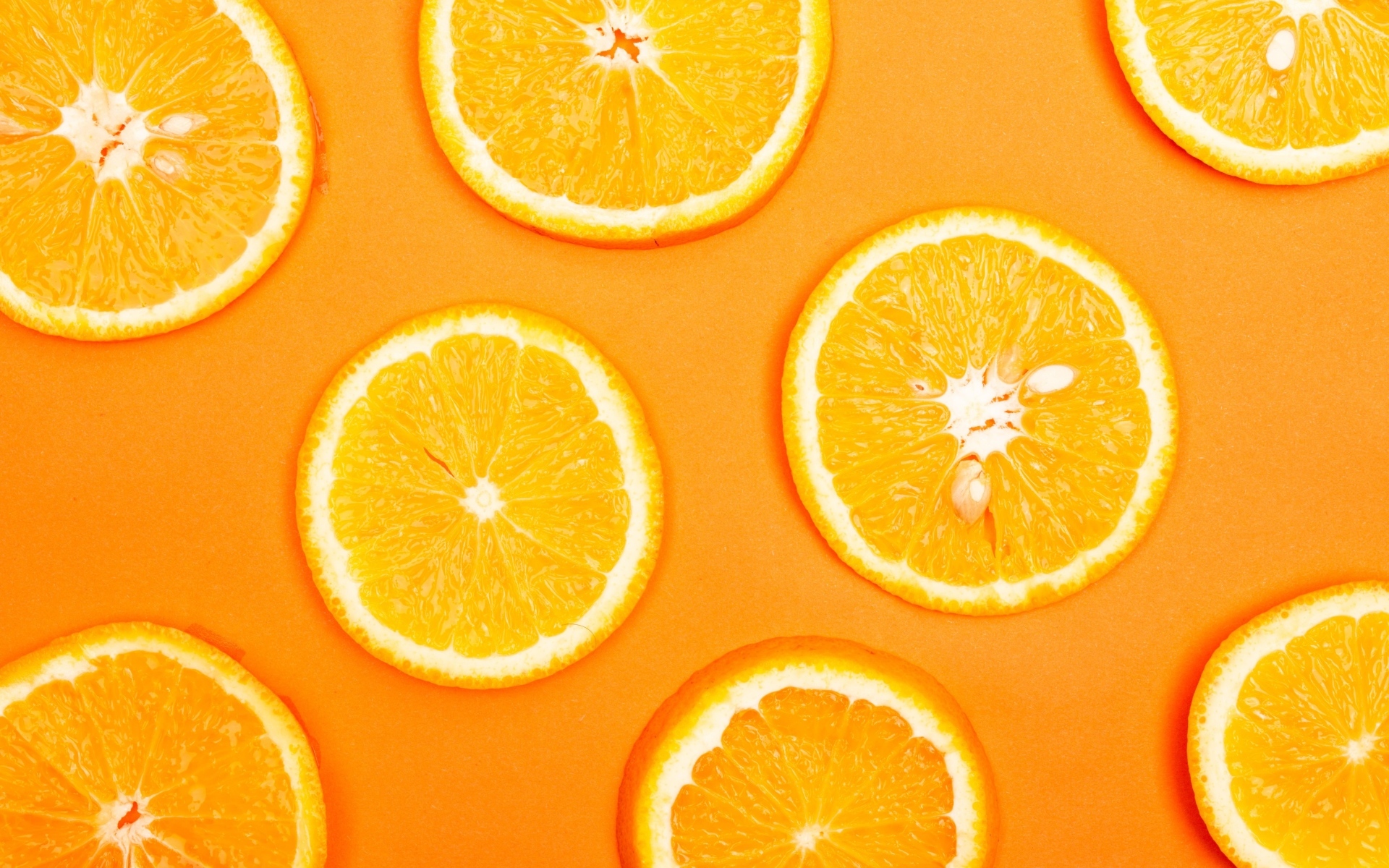 Спелый апельсин на оранжевом фоне