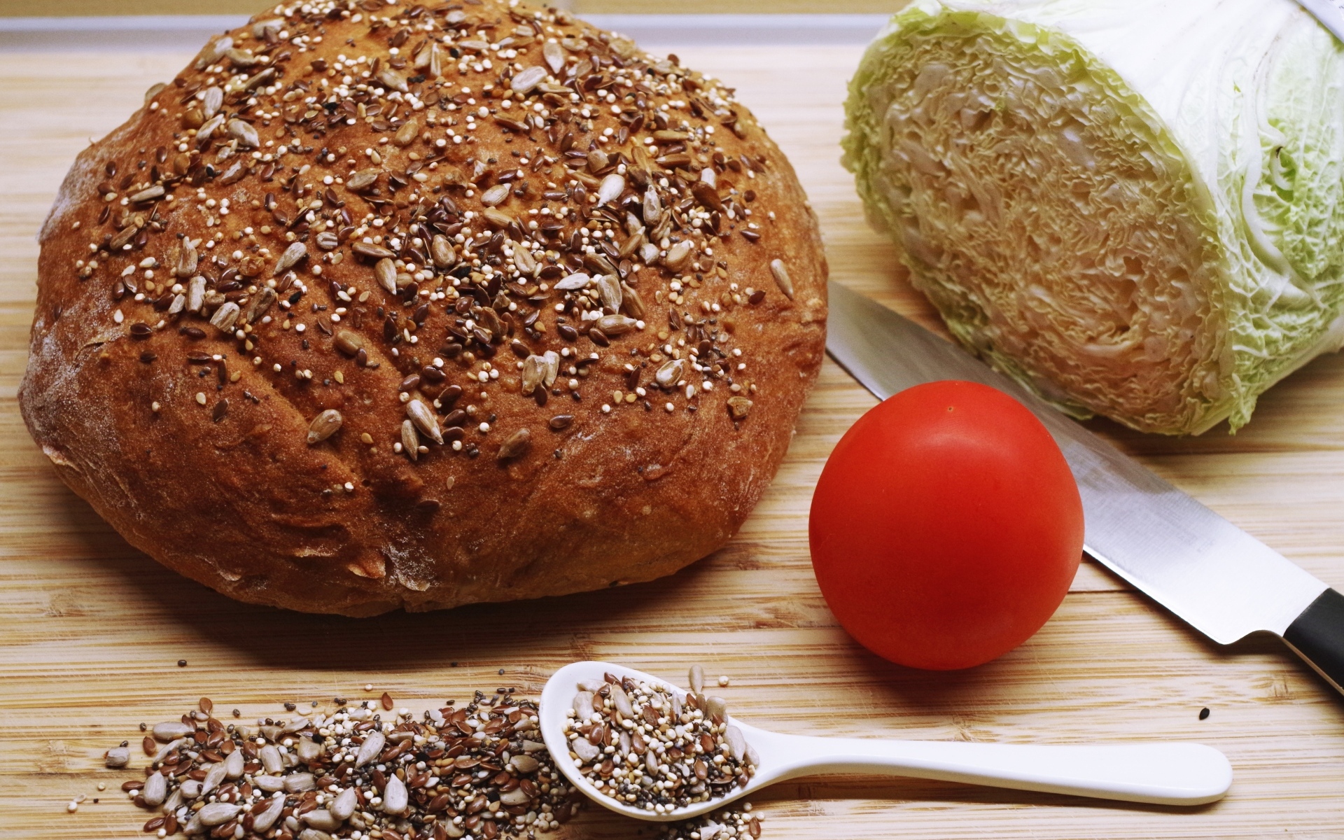 Буханка хлеба на столе с капустой и помидором