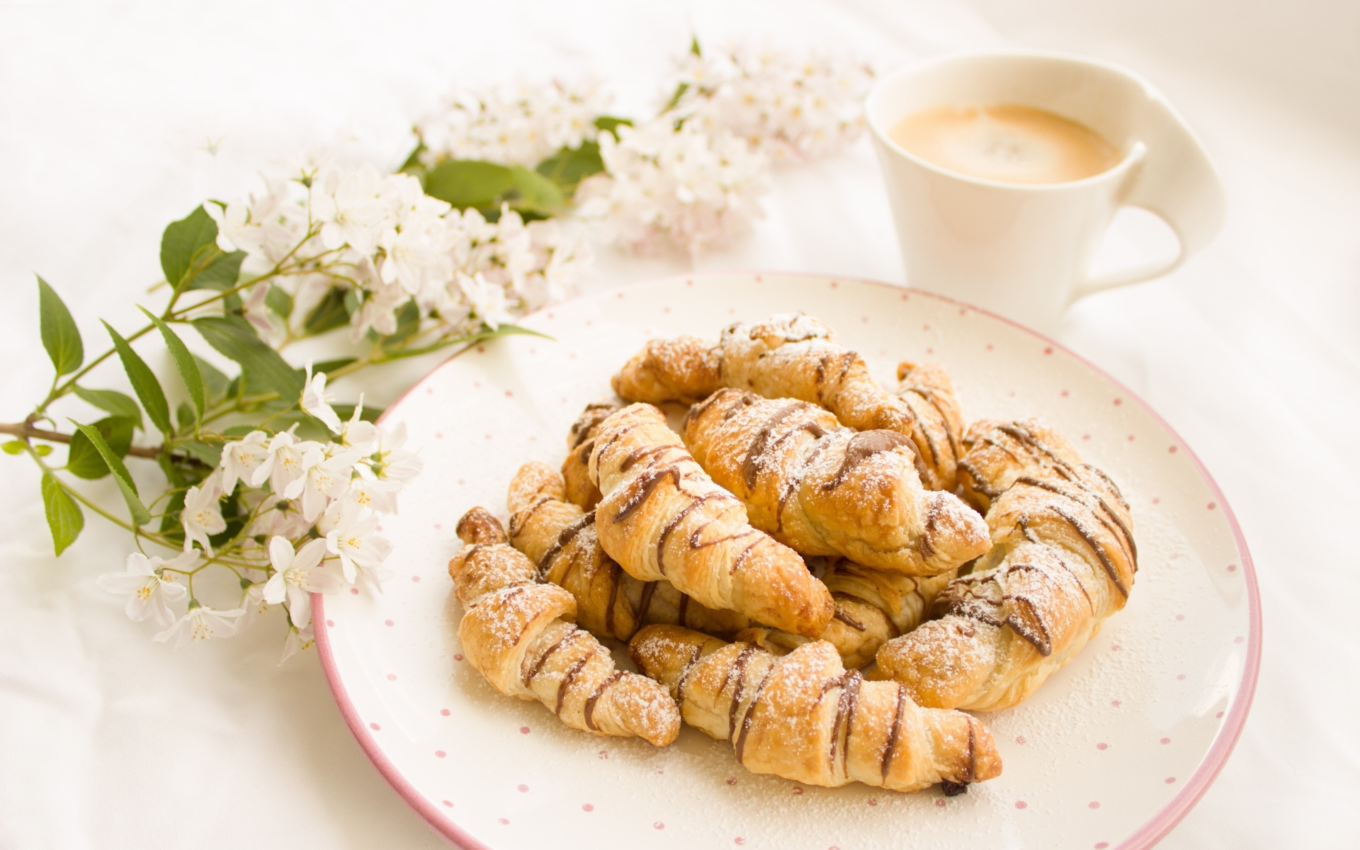 Круассаны на столе с кофе и цветами