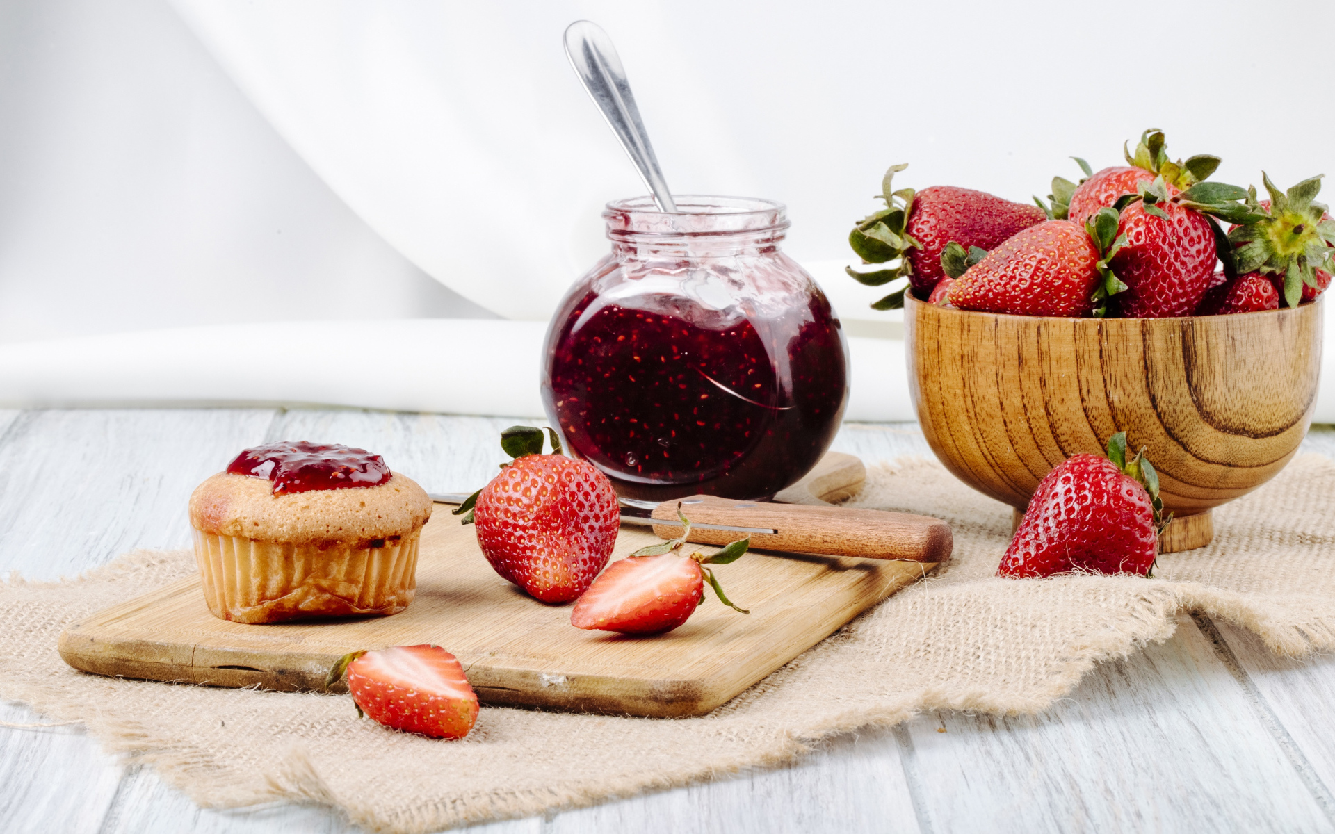 Кекс со свежей клубникой и джемом на столе