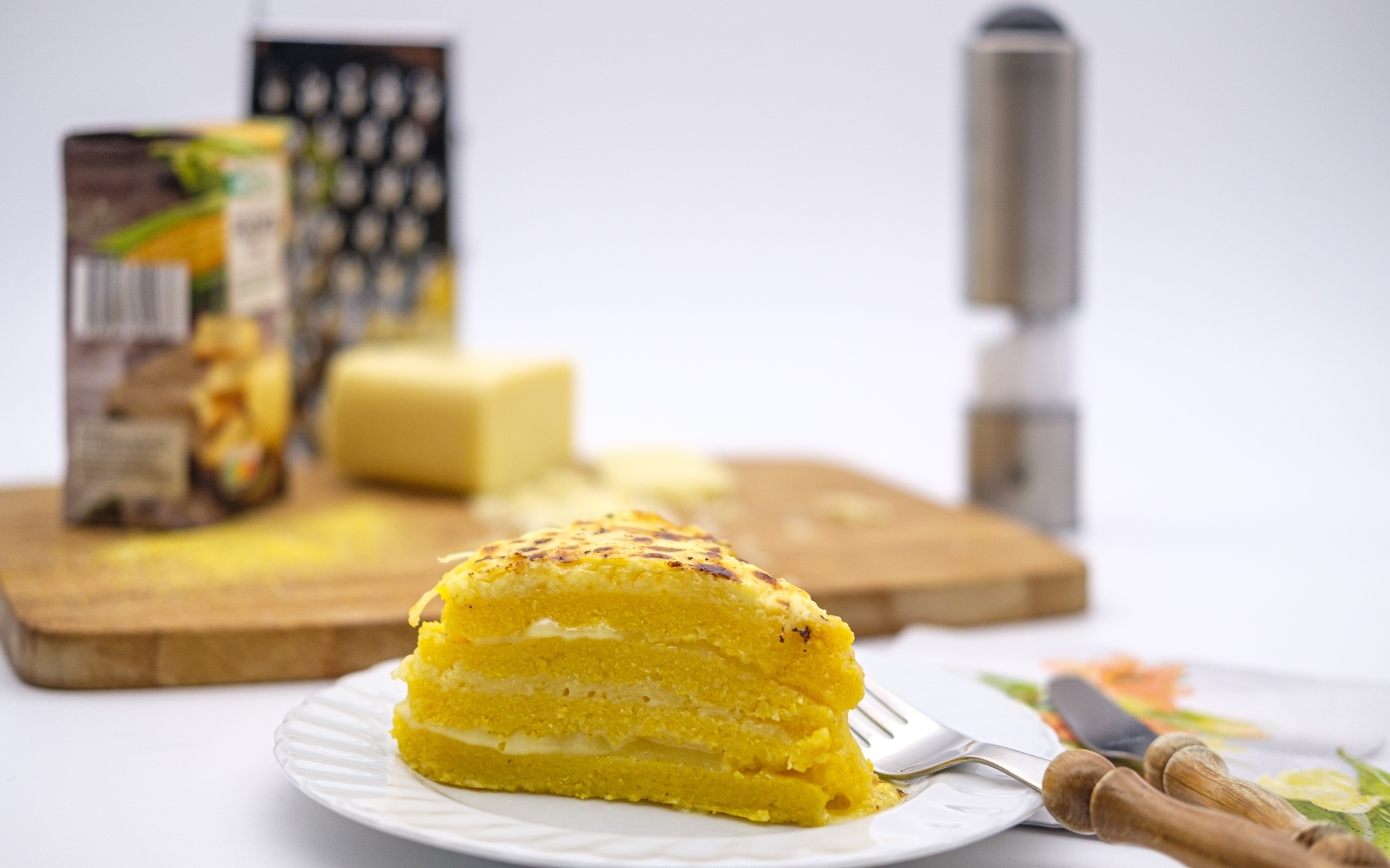 Кусок торта на столе со столовыми приборами