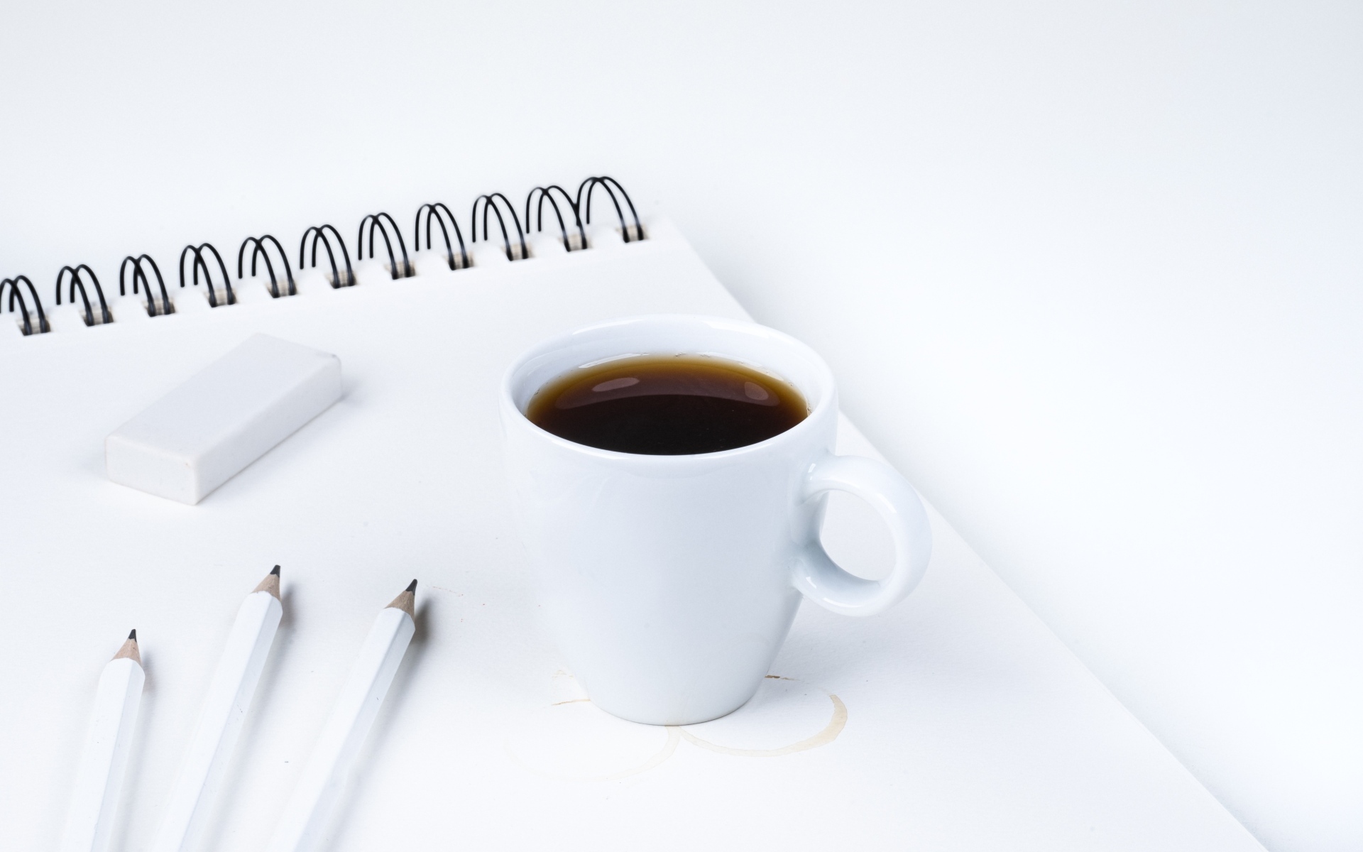 Чашка ароматного кофе с блокнотом на столе