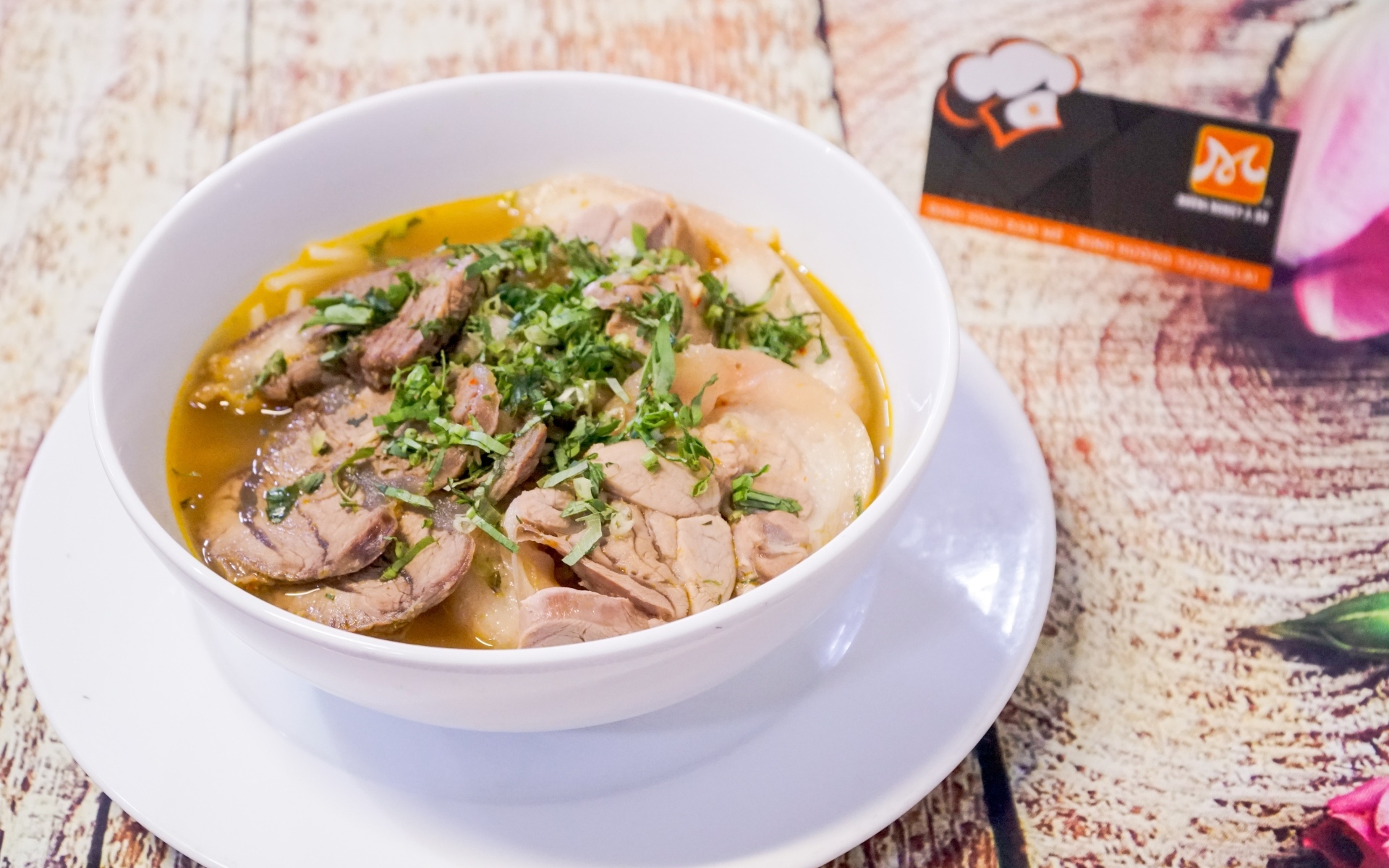 Бульон с мясом в белой тарелке на столе