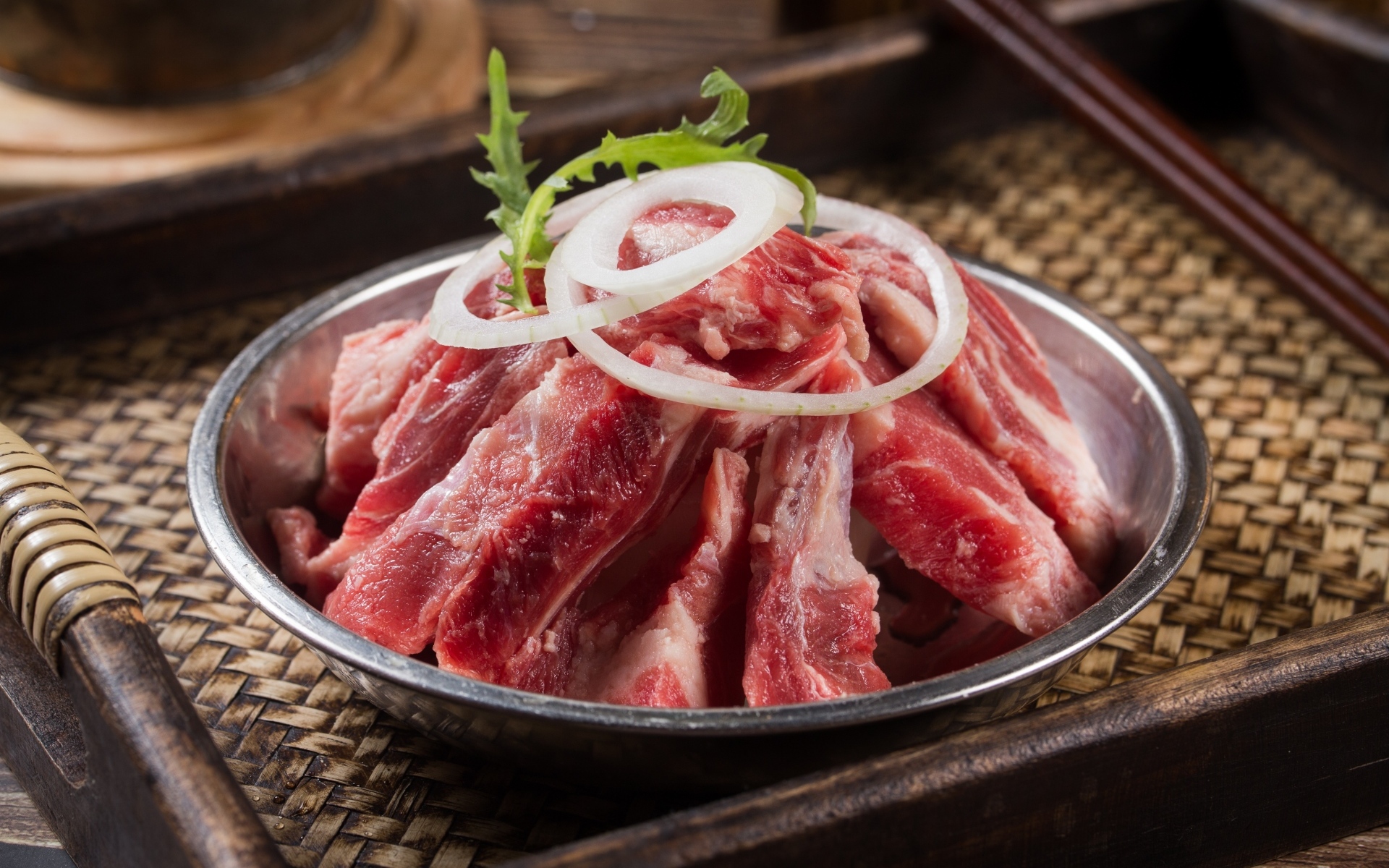 Свежие свиные ребра с луком в миске