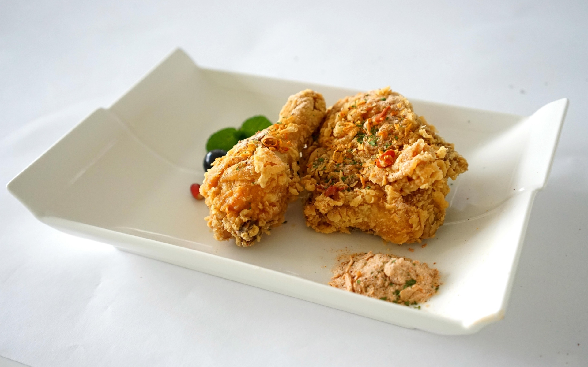 Жареная хрустящая курица в тарелке на столе