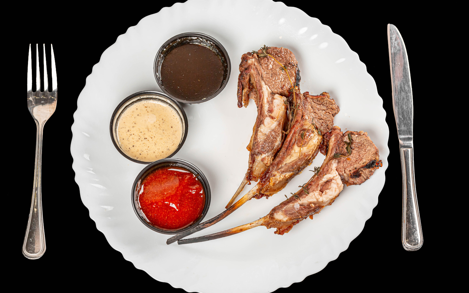 Свиные ребра с соусом на белой тарелке 