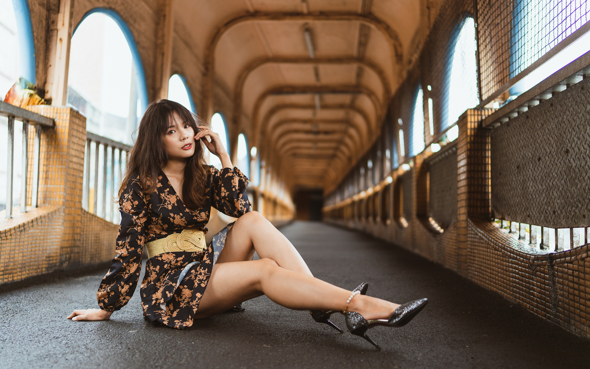 Девушка в красивом коротком платье сидит на полу