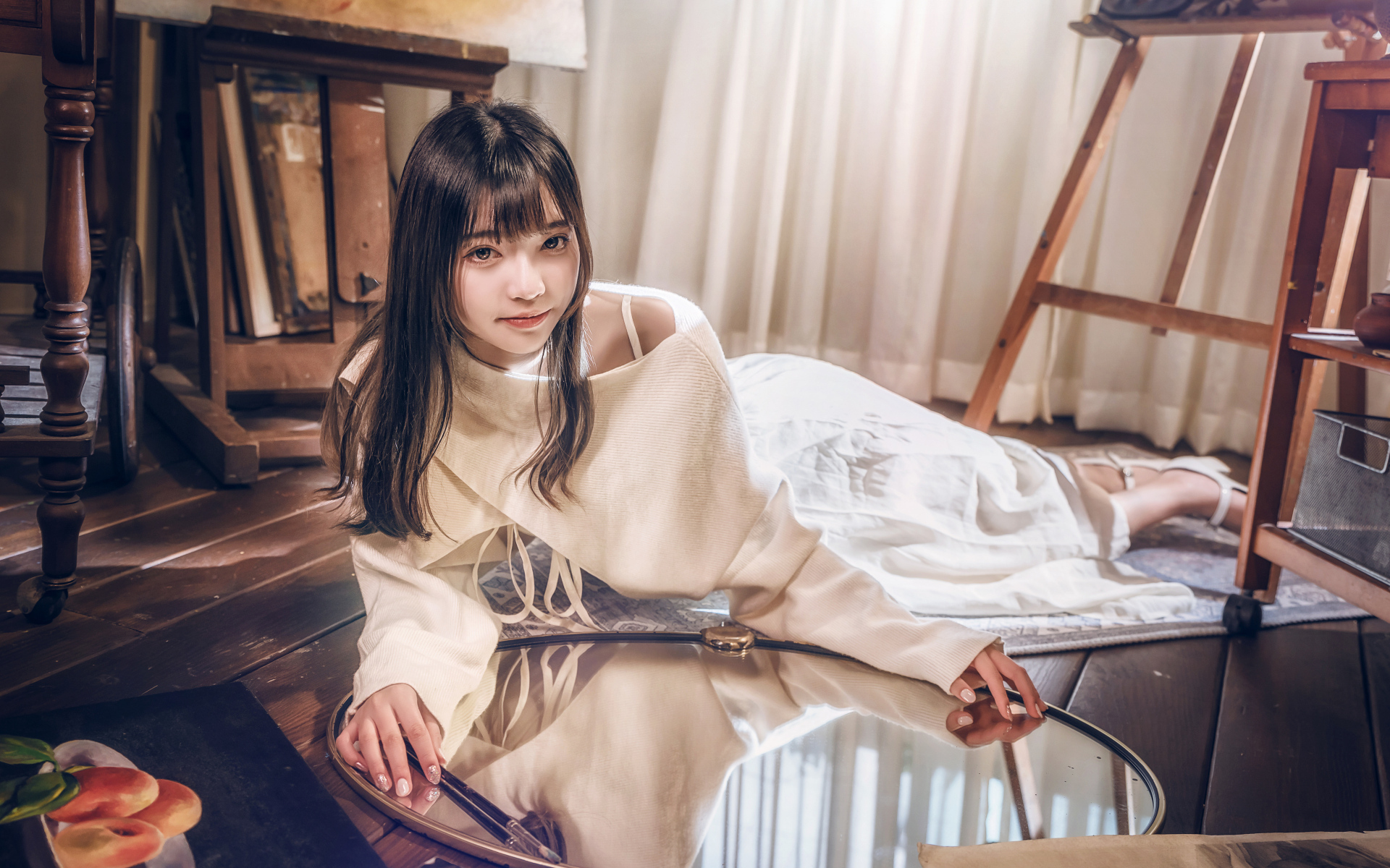 Девушка азиатка в белом платье лежит на полу