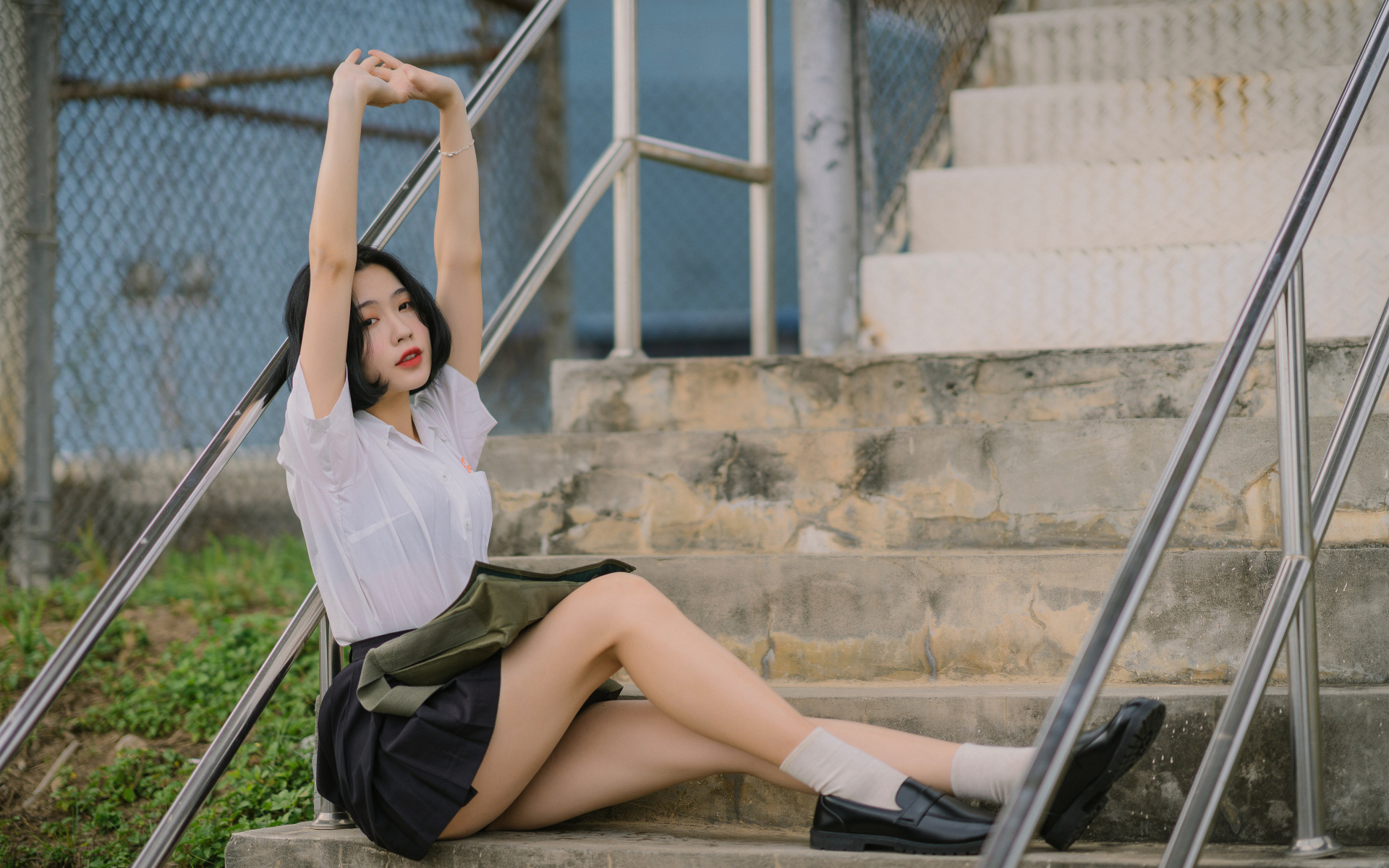Девушка азиатка потягивается на ступеньках