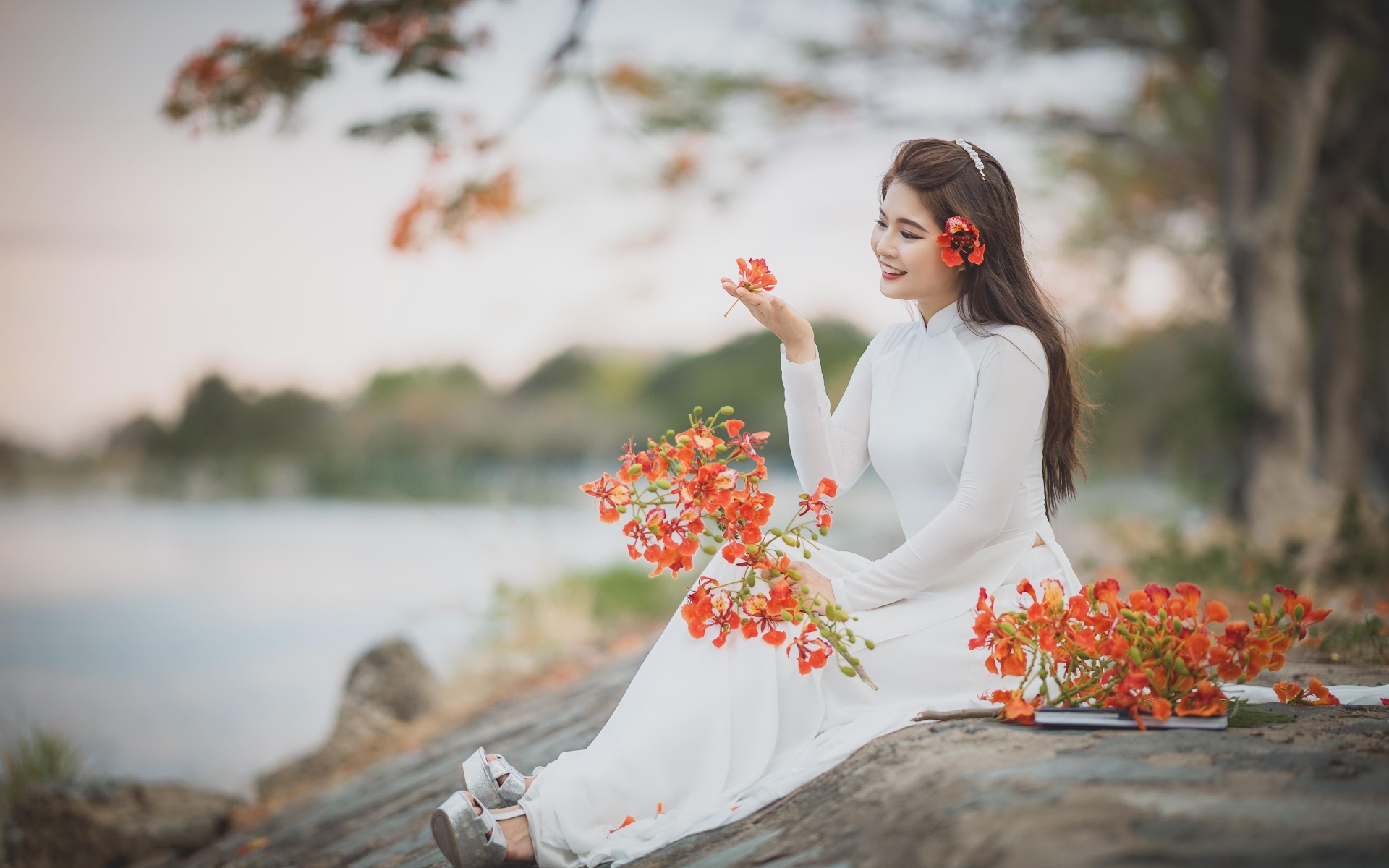 Красивая девушка азиатка в белом платье с цветами в руке