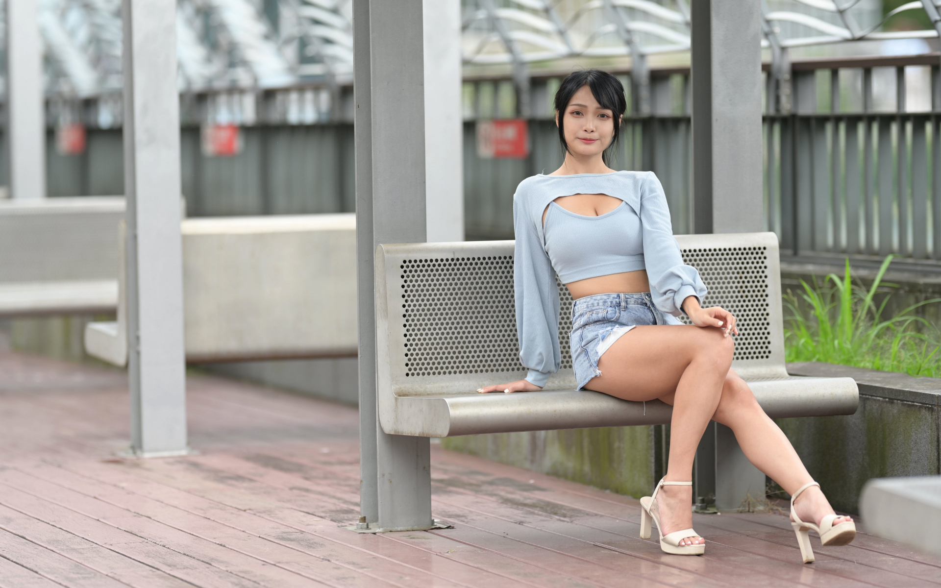 Красивая темноволосая девушка азиатка сидит на лавке