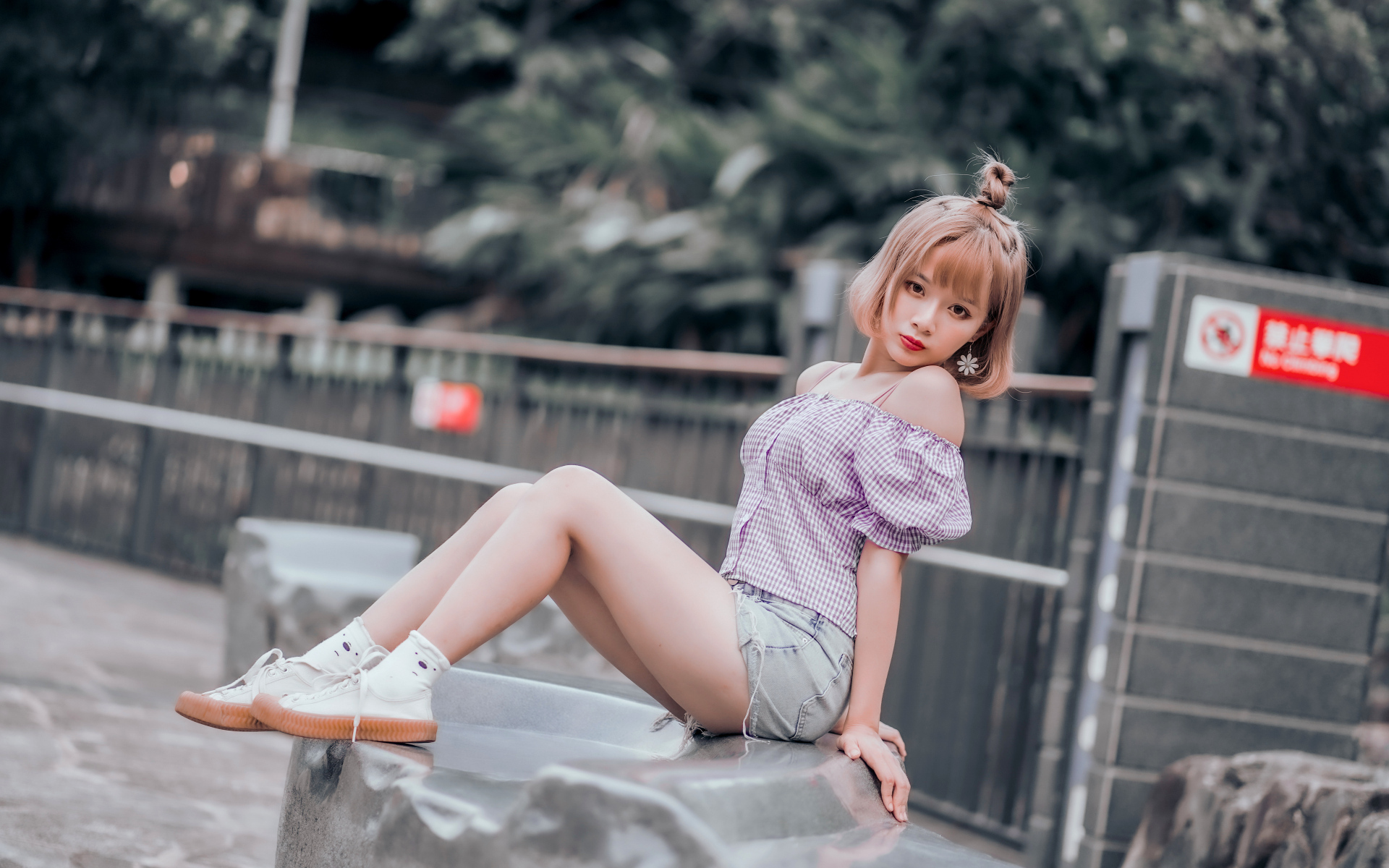 Милая девушка азиатка сидит на камне