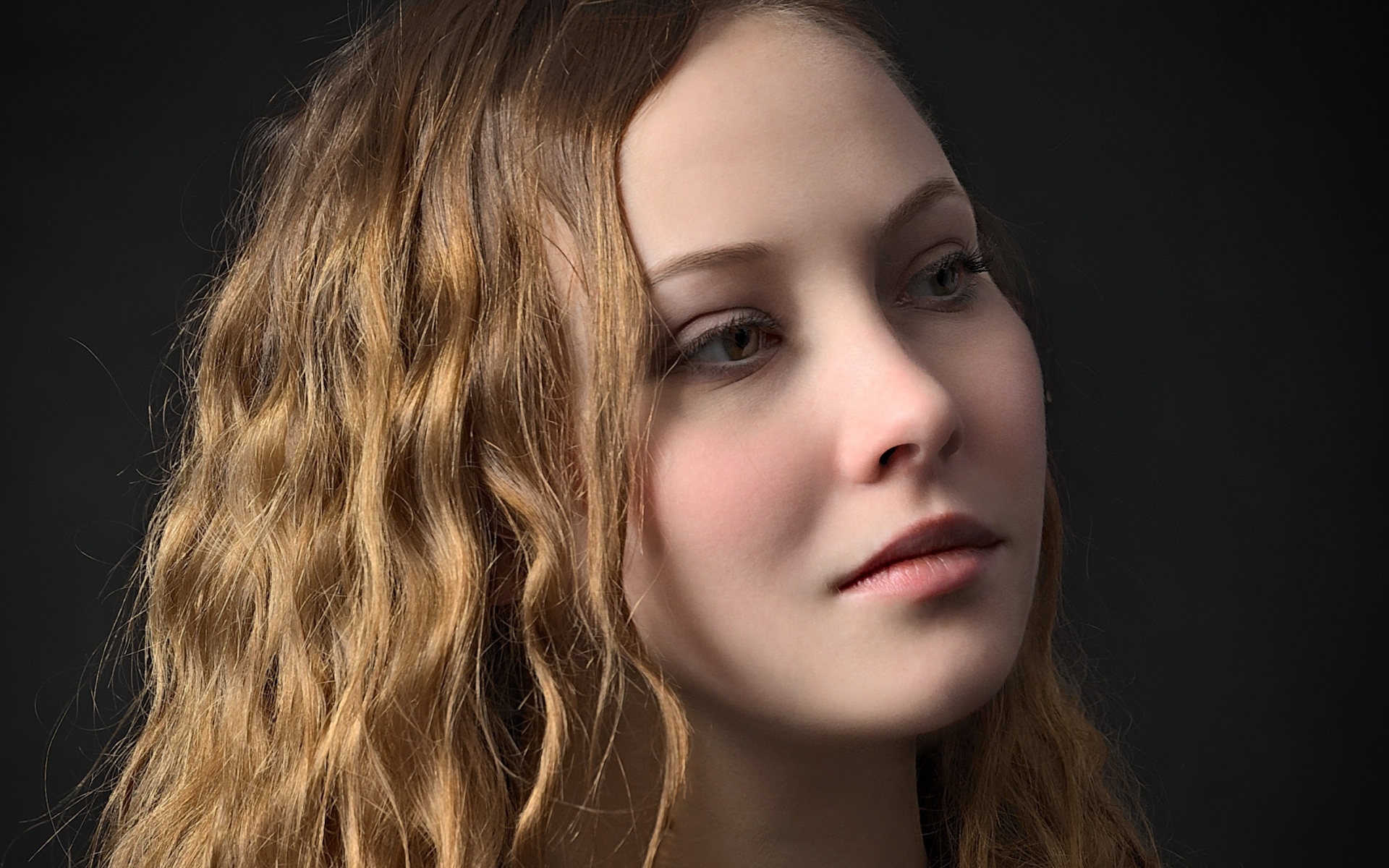 Длинноволосая кареглазая девушка на черном фоне