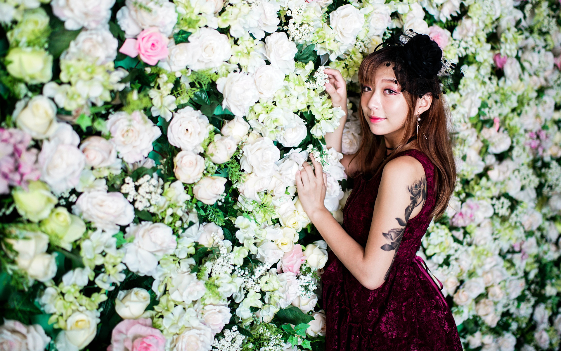 Молодая азиатка на фоне стены с розами